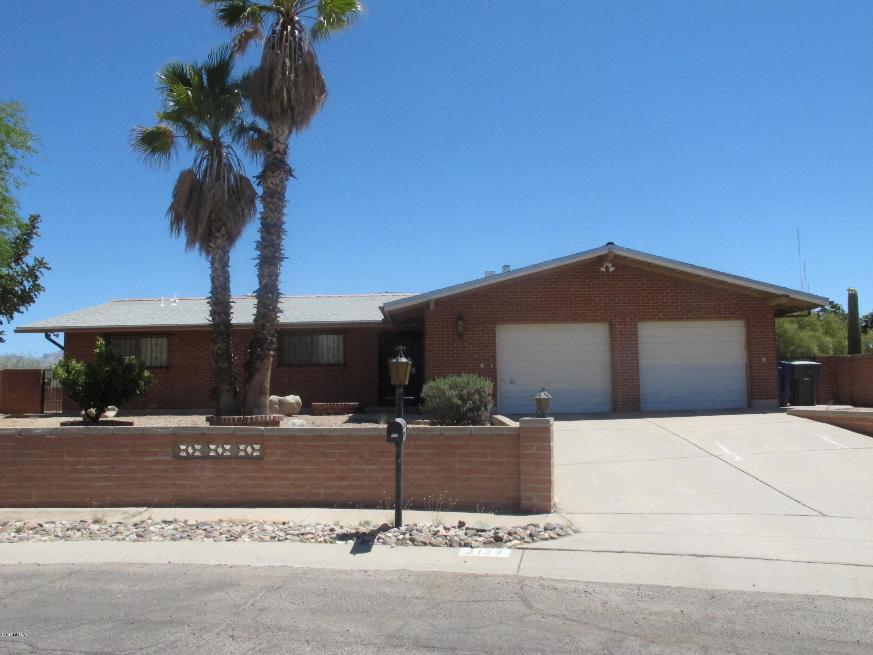 This charming brick house comes with three bedrooms, two baths, and two car garages  on almost a quarter acre.  This house also features a family living room with double door fireplace, a formal living room, a breakfast nook, open kitchen window to the backyard, and a WOK room.  The backyard is a great place to view the Catalina mountain and enjoy the  built-in barbecue.  The location of the house is conveniently near the University of Arizona, West and Downtown Pima Community College as well as Joaquin Murrieta Park, El Rio Golf Course, shopping centers, and restaurants.  There is also no HOA!   Please call Anne at 520.704.2305 to view the house!