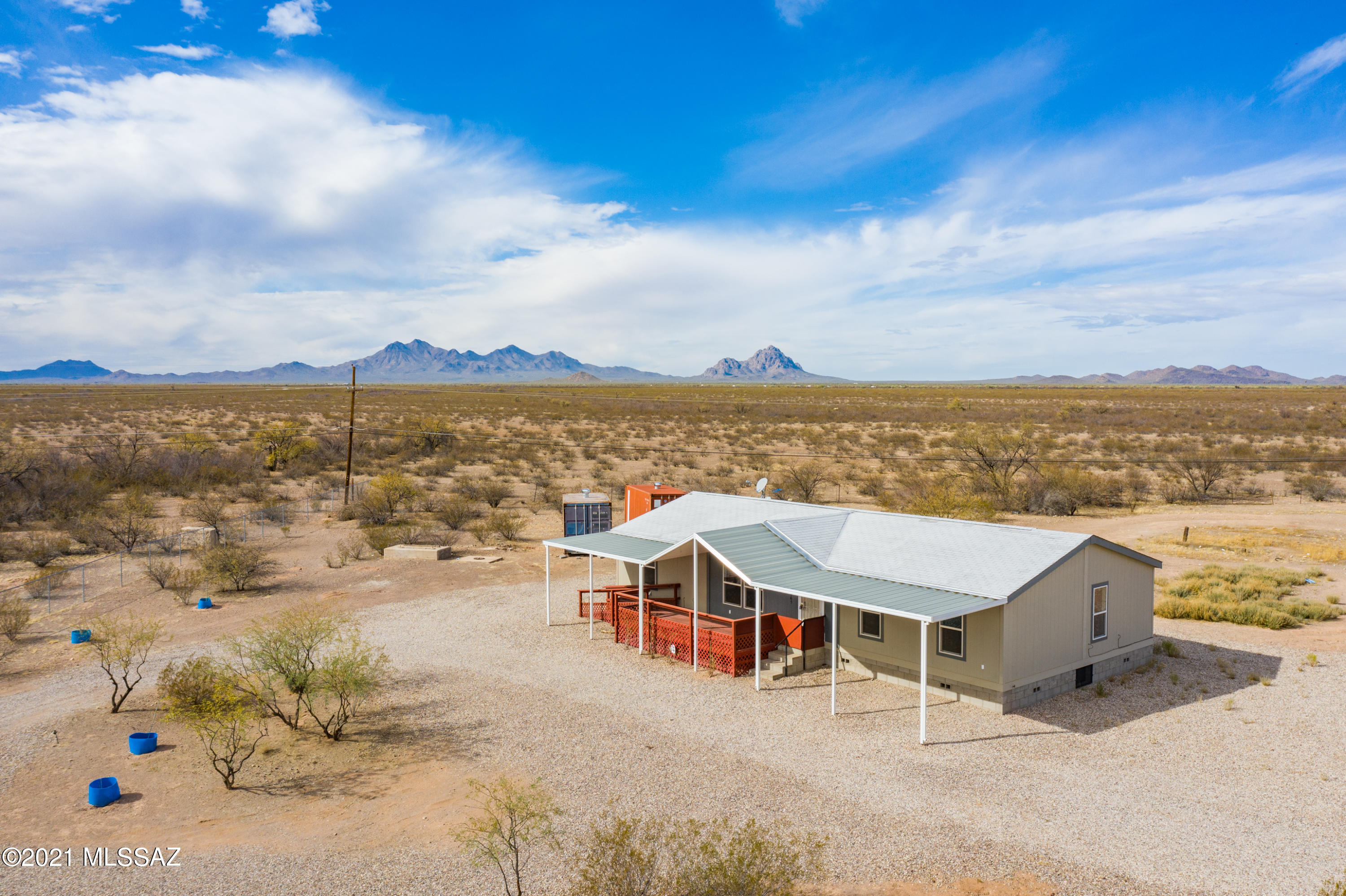 Nestled in the quiet natural beauty of Marana, bordering Federal land, this beautiful 2016 Cavco Manufactured Home can be your paradise. This lovely home features 3 bedrooms, 2 baths, a separate family room, and an open Great Room floor plan. Kitchen features include cherry cabinets, black appliances, breakfast bar island, hanging pot rack, & glass tile backsplash. BRAND NEW CARPET in bedrooms and family room. Wood laminate flooring in the rest. Front deck with ramp for easy access. Block foundation. Awnings on front and rear of the home provide covered parking & protection from the sun. 2 shipping containers and a chicken coop round out the structures.  FULLY FENCED 1.15 acre lot with fruit trees and plenty of room for your outdoor living plans. Close to gas, convenience stores, and more!