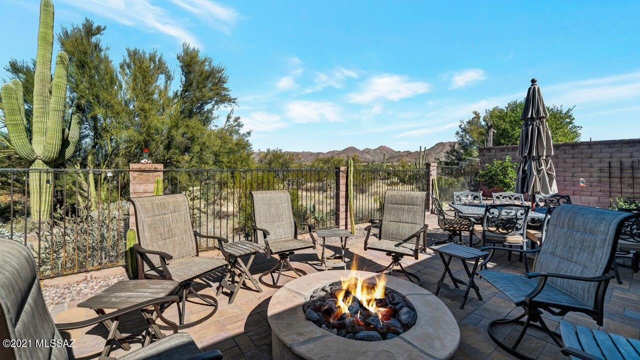 Gated Dove Mountain at the Preserves!  Tranquil rear yard overlooking OPEN DESERT & MOUNTAIN VIEWS. Entertainer's delight has hot tub, paver patio, Pergola covered built in kitchen w/BBQ/smoker w/ 7 burners. Covered patio area fan, screens & awnings and gas fire pit for chilly evenings. Private courtyard leads to foyer entry to spacious great room & kitchen w/ FP & windows w/ a great view! Formal dining. Kitchen has staggered upper cabs, SS range hood over cooktop, walk in pantry, bar seating on island & family dining space. Secluded master w/ bay seating, patio access, soaking tub, shower w/ bench, Walk in closet. BR 2 has ensuite bath w/ roomy shower, BRs 3 & 4 share hall bath. BR 4 has queen Murphy bed & is currently an office. Den has double doors for privacy. 3 car garage !