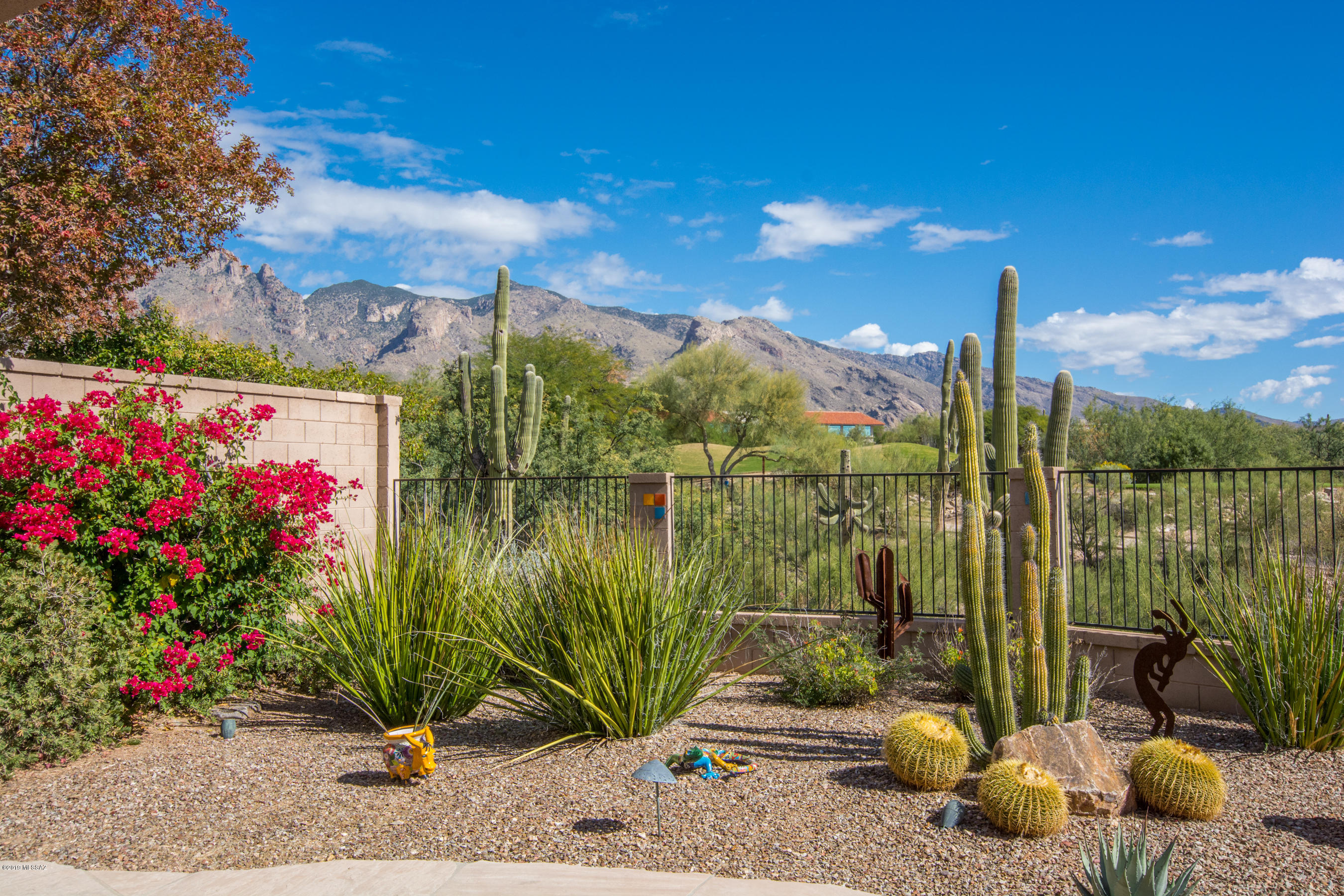 Spectacular Sunrises, gorgeous Mt & Golf Course views await you in this Contemporary 4BR/2BA/2 Car Garage in the Villages of La Paloma. Entry with Custom iron screen door opens onto the hall looking towards the Great Room with FP, Kitchen with upgraded cabinetry, pantry & Breakfast Bar island overlooking the Dining Area and Great Room. Be captivated by the views from the interior of the home. Private, king sized Master Bedroom with Walk-In Closet & Bath features dual vanity, sep Garden Tub & Shower. Guests will appreciate the split Bedroom floorplan.  Enjoy the gorgeous yard with extended flagstone covered patio, built in BBQ, views of the desert, golf course and Catalina Mts from this prime lot. The Villages offer a gated entry, lovely Community Pool area and great walking throughout!