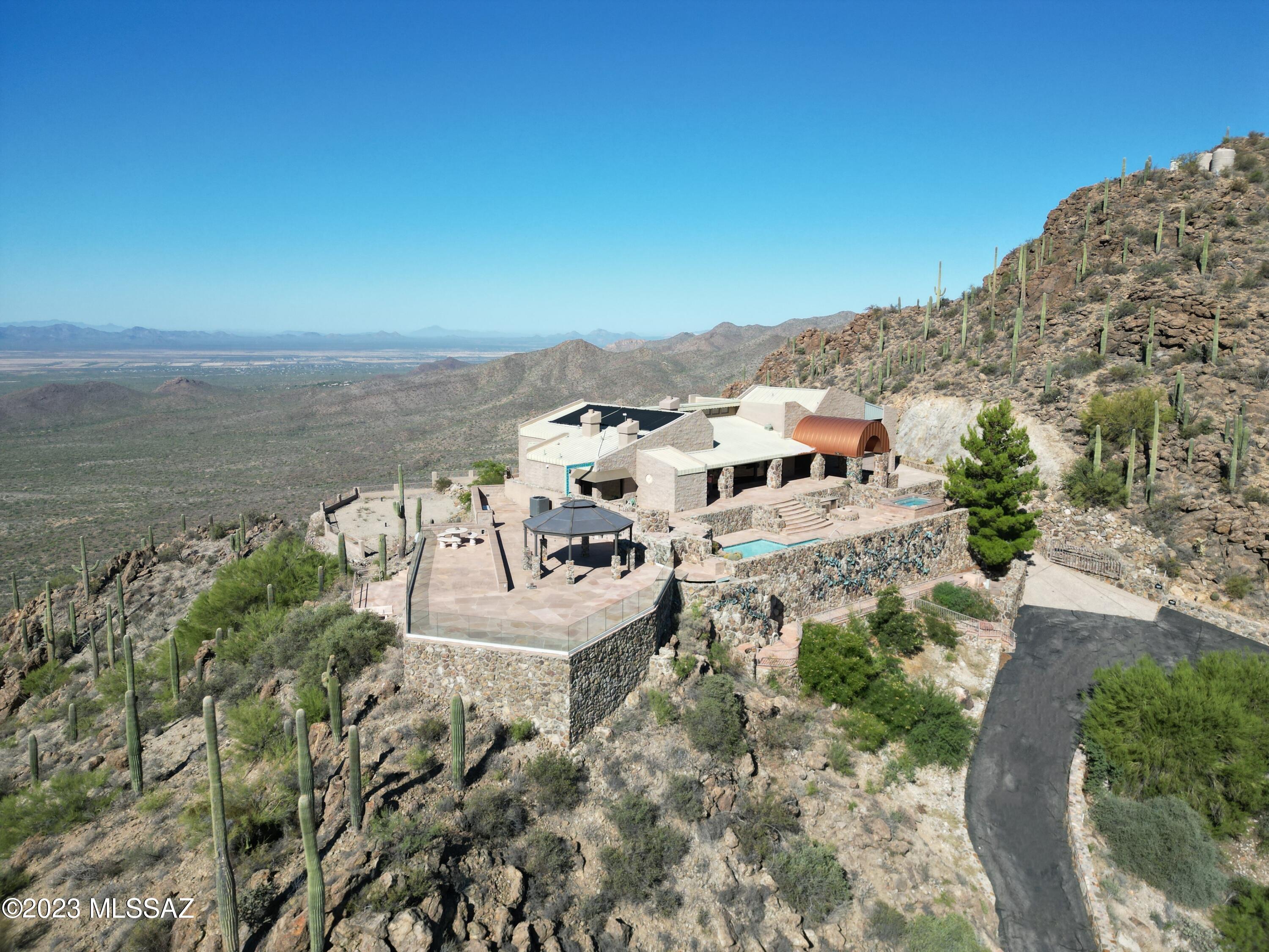DRAMATIC PRICE IMPROVEMENT! THIS IS A MUST SEE! Ascending Tucson's highest peak, the sturdy saguaro & mountain vistas of SKY CANYON offer a spectacle that must be experienced to be appreciated. Behind 3 security gates, the spacious 3,737 sqft residence includes 6,000+ sqft flagstone patio, outdoor kitchen, pool, separate spa & 360° SENSATIONAL VIEWS to relish the best of outdoor living. From first light to dusk, you'll be enchanted by a vast sky & dazzled by city lights at night! At 4,000' elev, this 3 bedroom, 4.5 bath home offers an expansive open floorplan, OUTSTANDING VIEWS FROM EVERY ROOM, a primary suite with stone fireplace, 2 walk-in closets & striking bath complete with jetted soaking tub, fireplace & granite walls. Recently upgraded with 2 New HVACs and custom window coverings.