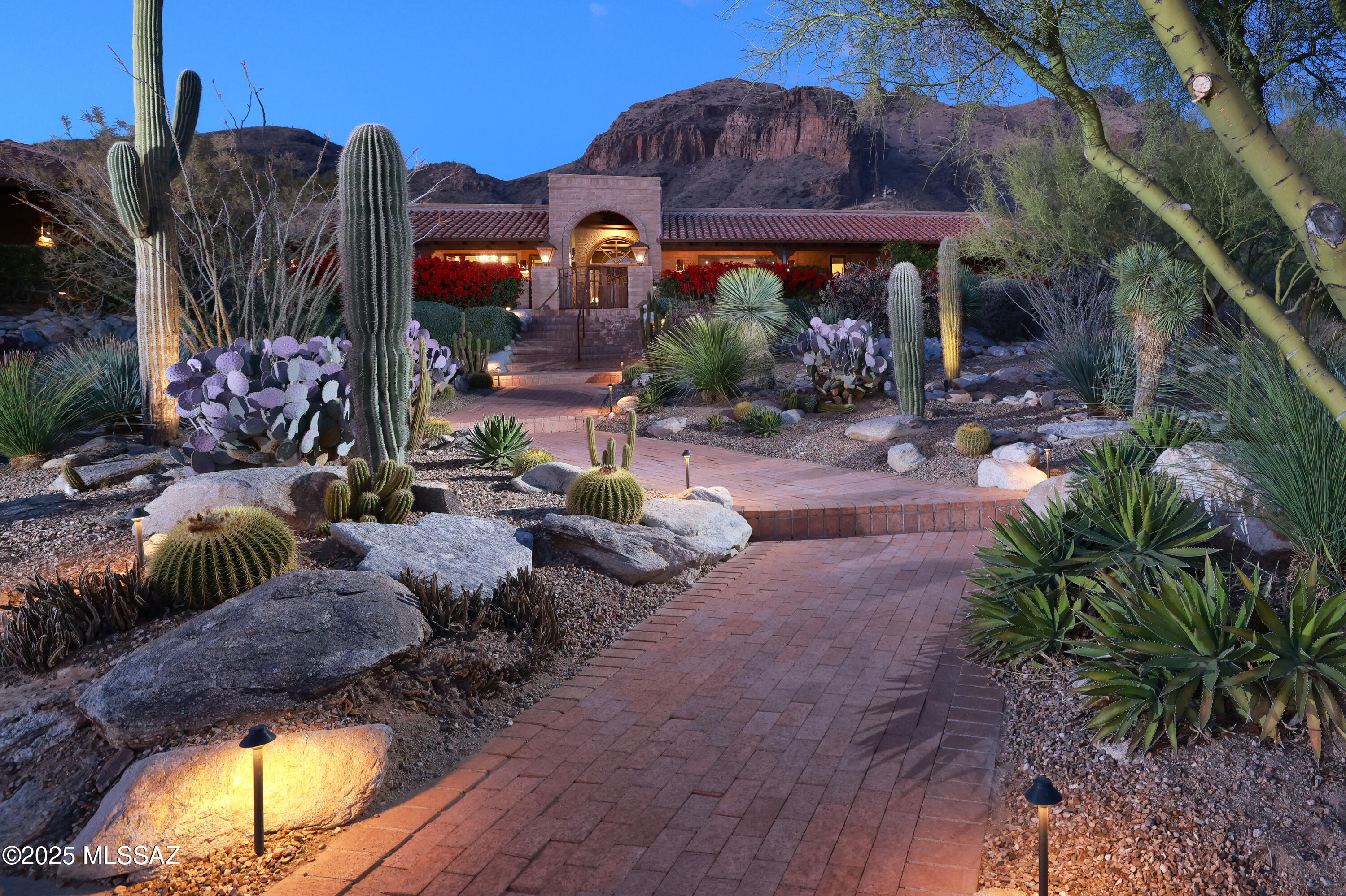 Nestled in the prestigious, gated Cobblestone community, this 4,339 sq. ft. custom territorial home offers an unparalleled blend of luxury, comfort, and breathtaking views. Impeccably sited to capture sweeping vistas of both the city skyline and rugged mountains, this single-level residence is a sanctuary of timeless elegance.

The expansive wrap-around veranda, complete with custom lighting, invites you to enjoy serene outdoor living and dining spaces framed by professionally designed landscaping, a tranquil courtyard fountain, and enhanced by new landscape lighting. Inside, the home boasts exquisite upgrades, including new stone flooring, refinished wood floors, and renovated bathrooms with premium finishes. The kitchen is a chef's dream, featuring an expanded island, granite countertops, a stone backsplash, and top-of-the-line appliances.

The thoughtfully designed layout includes a generous primary suite, an inviting den/library, and open living areas highlighted by large windows that perfectly frame the stunning views. An additional benefit is no interior steps throughout the home. Additional highlights include solid wood doors, custom cabinetry throughout, and charming stone fireplaces with custom mantles. The attached guest quarters with a kitchenette provide a private retreat for visitors.

With its oversized three-car garage and proximity to La Encantada's shopping and dining, this property offers both quiet seclusion and convenient access to the best of Tucson living. Experience the perfect balance of sophistication and comfort in this remarkable Cobblestone gem.