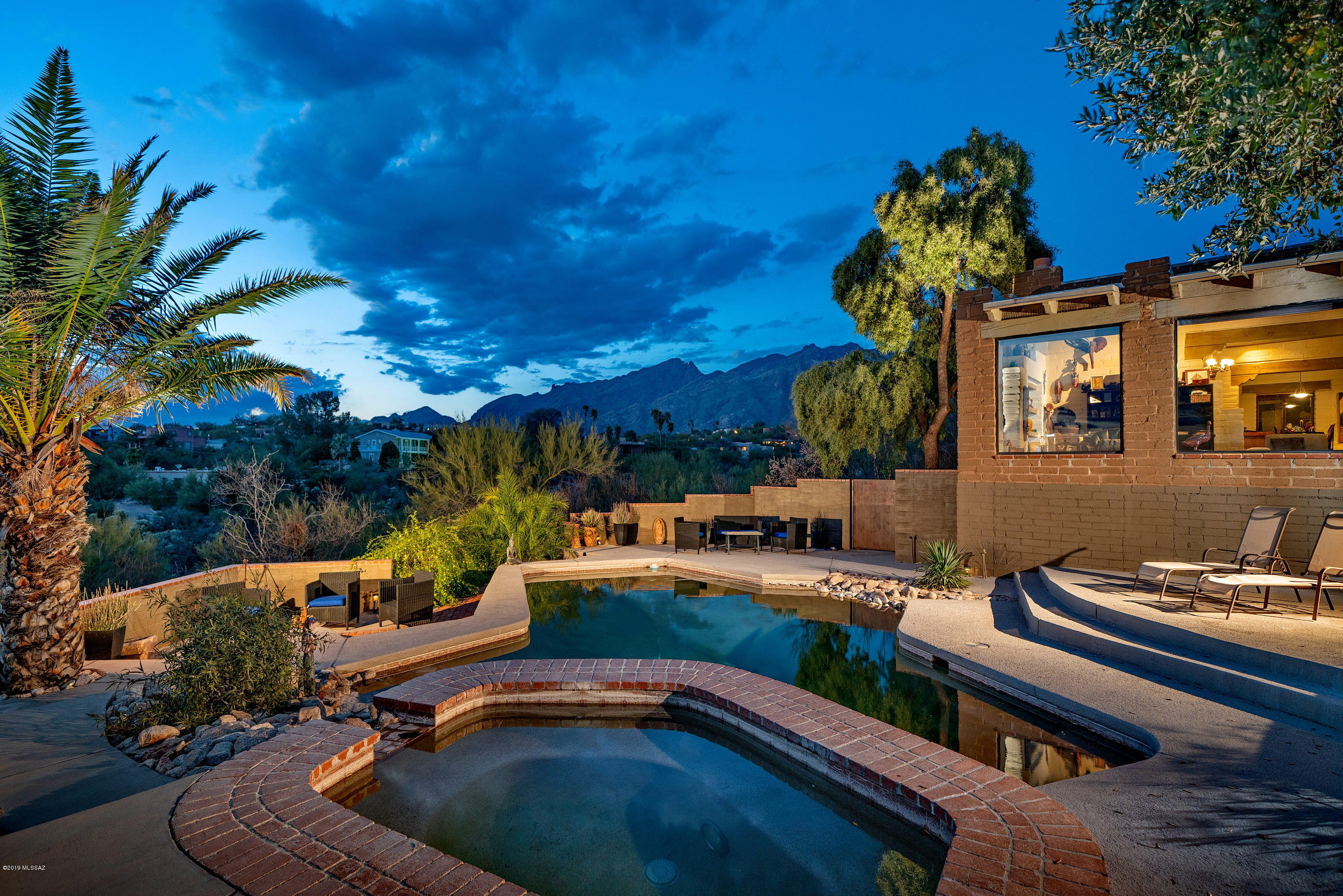 This custom Gary Williams Mud Adobe home offers complete privacy from outside in. Situated on a 1.54 acre private hilltop with stunning Catalina Mountain, as well as sunset and city light, views stretching out over the valley below. Enter through a private courtyard into a high design interior space that complements and reflects the vernacular, utilizing a delicate balance of tones, textures and finishes, providing the ideal back drop for the individual design sensibility. Constructed of stabilized Mud Adobe, this mass wall system offers substance as well as thermal properties, perfectly suited for our desert climate. 4,024 sqft of interior living space is comprised of 3 Bedrooms and 3 Baths, 6+ car garage, art studio/flex space and a converted living room, perfect as a tranquil retreat, or for cozy family living.Maximizing the house's dramatic relationship between interior and exterior spaces is achieved through careful design and placement of the structure with connectivity to the surrounding landscape. Exterior transitional spaces are rich in mobility with the capacity to enjoy and entertain being effortless, emphasizing views that extend through the great room and outdoor living spaces, sweeping out beyond the pool/spa and into the surrounding view corridors.