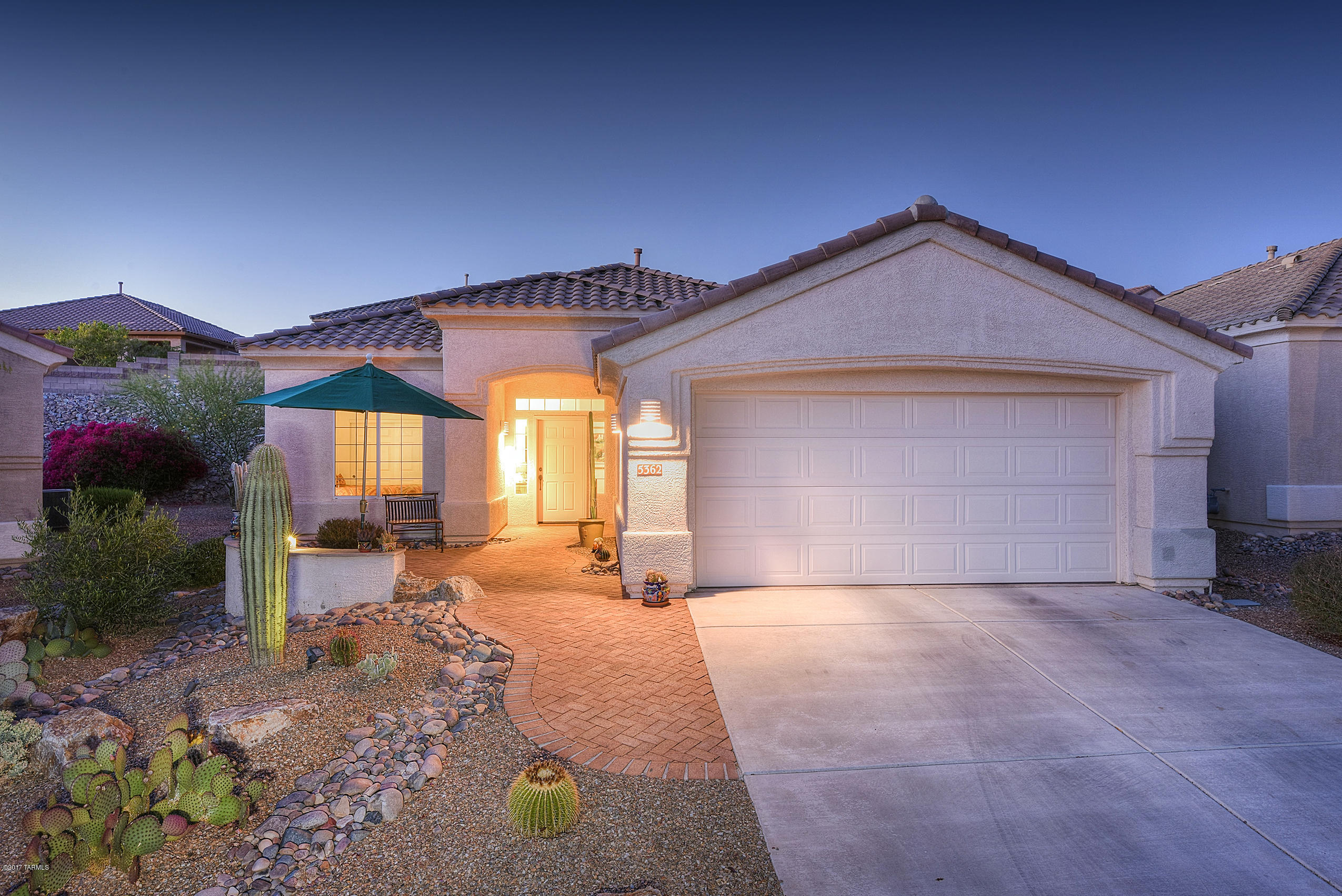 Fabulous value for this highly desired Hillsboro model. 2 bedrooms + den/office. Quaint brick paved front courtyard w/seating area to enjoy Marana city lights & mountain views. Spacious kitchen with 36'' extended  hickory cabinets, pull out drawers + all kitchen appliances included.  20'' tile in all traffic areas. Private double door den/office. Very private backyard w/relaxing water feature, landscape lighting, extended brick paved patio area, fruit trees, BBQ grill station & mature landscaping. Spacious master bedroom has door to rear patio. Custom blinds on all windows. Newer drip system - low care landscape front & rear. Washer & dryer are also included making this Hillsboro model truly move in ready! Home located near the end of a cul-de-sac street - very quite and private location