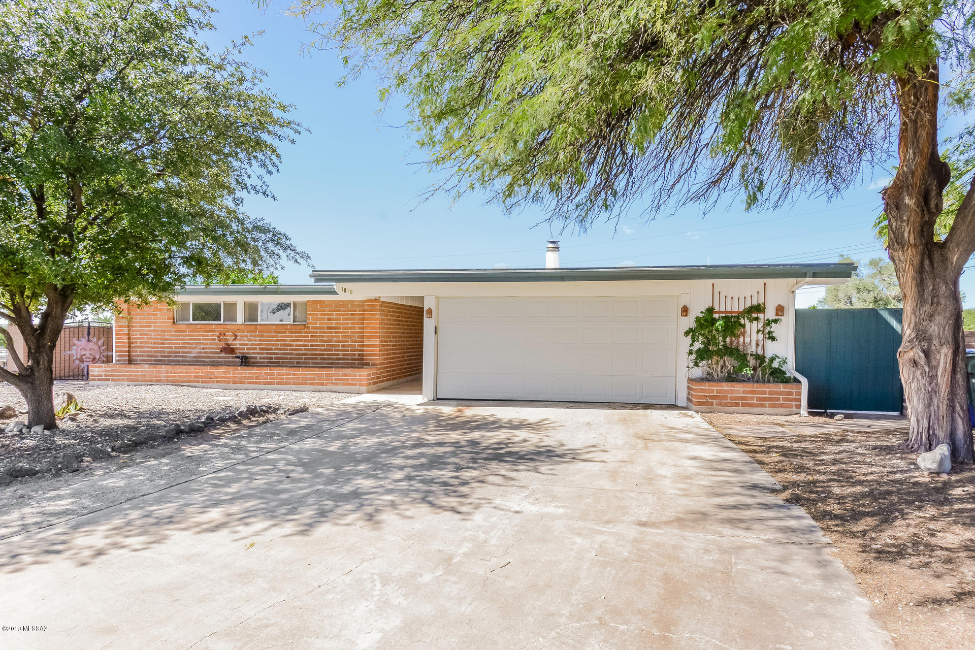 This Tucson one-story home on a golf course offers an in-ground pool, an enclosed patio, a wood-burning fireplace, an island kitchen with stainless steel appliances, a master suite with a private bath and walk-in closet, and a two-car garage.
