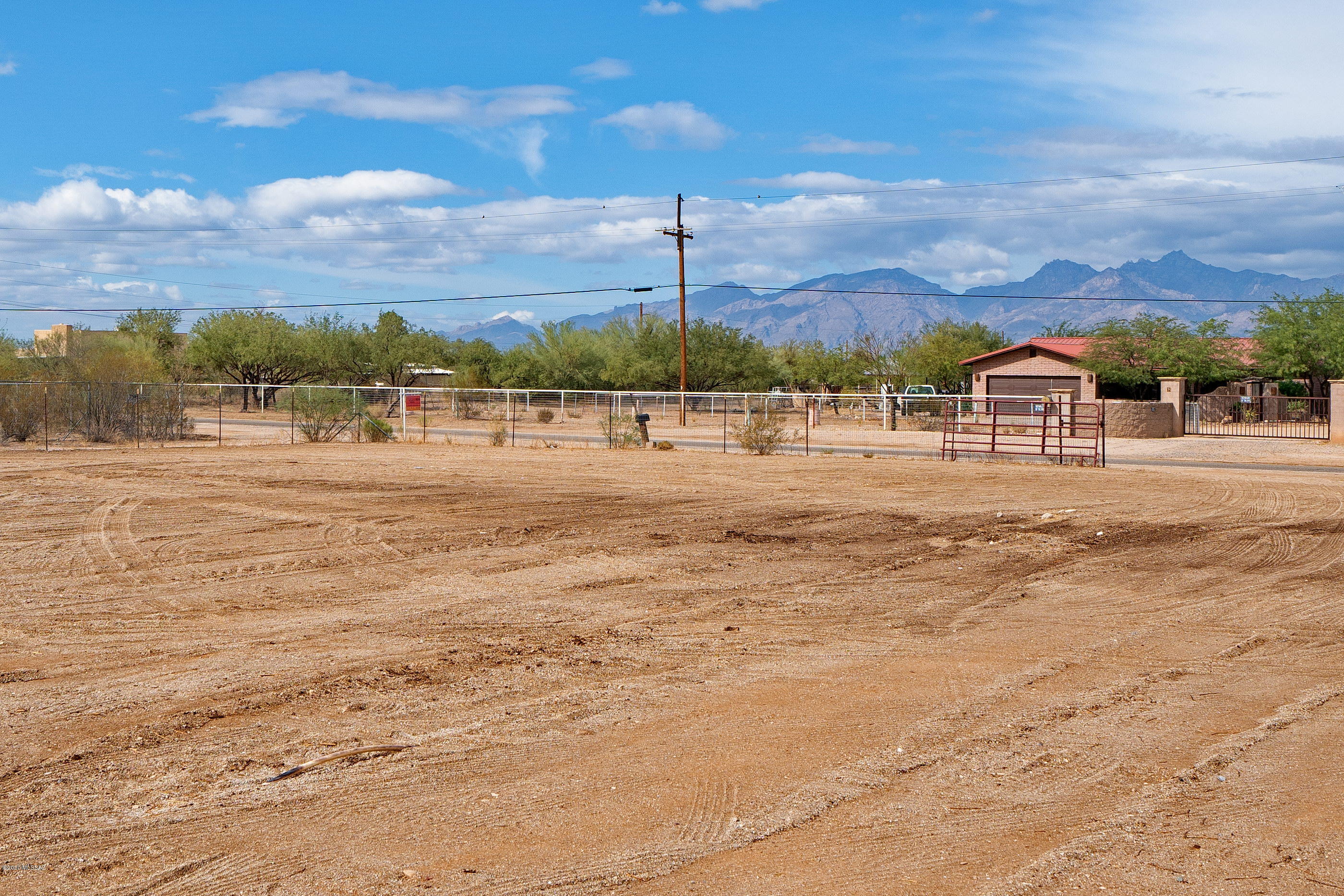 Large fenced and gated area for horses or hobbies with water and shade structure. Wrap around 360 degrees covered patios with metal roof and 4 vehicle truck port. No flood zone, no washes on property! 2002 built home has 3 bedrooms and 2 bathrooms. City water and sewer. Cleared flat lot, no HOA. Contemporary interior with 2019 AC, high ceilings, ceramic tile floors, ceiling fans, walk in closets and open living area. No Carpet! Plenty of excess land for pool, ramadas and entertaining space. Nearby wash for riding.