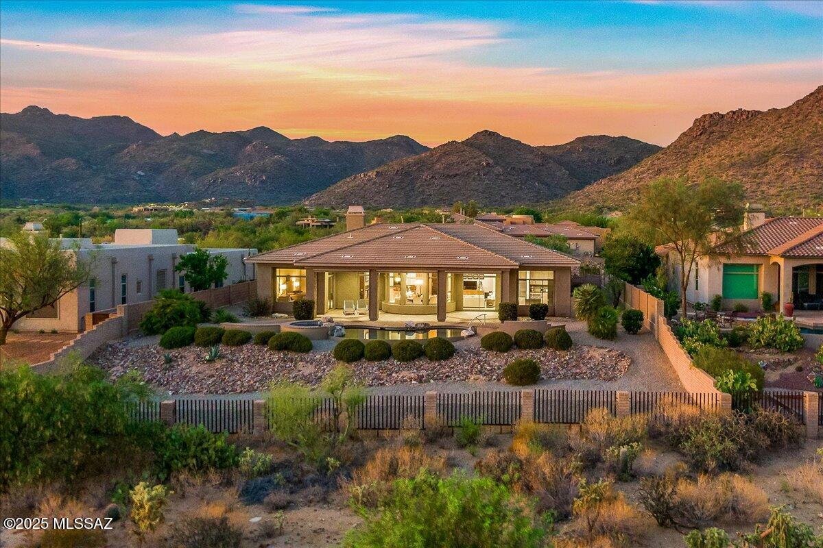 Discover sophisticated desert living in this beautifully upgraded Toll Brothers estate, perfectly positioned on the 11th fairway of The Gallery North Course in the exclusive gated community of Solana at Dove Mountain. Set on a private 0.51-acre lot in the scenic Tortolita Mountain, this architectural masterpiece showcases sweeping golf course, mountain, and sunset views through panoramic walls of glass.

Inside, the heart of the home is a striking gourmet kitchen featuring a nearly 15-foot quartz island, custom oak cabinetry, GE Café appliances, a 36'' gas range with downdraft, and a sleek toffee-toned backsplash perfect for both everyday living and upscale entertaining. The open-concept living and dining areas offer 12' ceilings, elegant porcelain tile flooring, and upgraded lighting and ceiling fans. A two-story foyer adds dramatic entry appeal, while a bonus room/den and a private office provide functional flexibility. The living room is anchored by a granite-wrapped gas fireplace and a dry
bar with tumbled marble face and granite countertop.
Each of the three bedrooms features en-suite privacy. 

The luxurious primary suite boasts 12' ceilings, Hunter Douglas blinds, two walk-in closets, and a gas fireplace with tumbled marble surround. The spa-like primary bath includes oak cabinetry and granite countertops. Built in wet bar . 

Step outside to your own resort-style retreat featuring a PebbleTec heated pool and spa, electric patio screens and expansive covered patio with sweeping views perfect for year-round entertaining.

Located just minutes from The Ritz-Carlton, world-class golf, hiking/biking trails, and private club amenities, this home offers luxury, comfort, and convenience in one of Dove Mountain's most desirable neighborhoods.