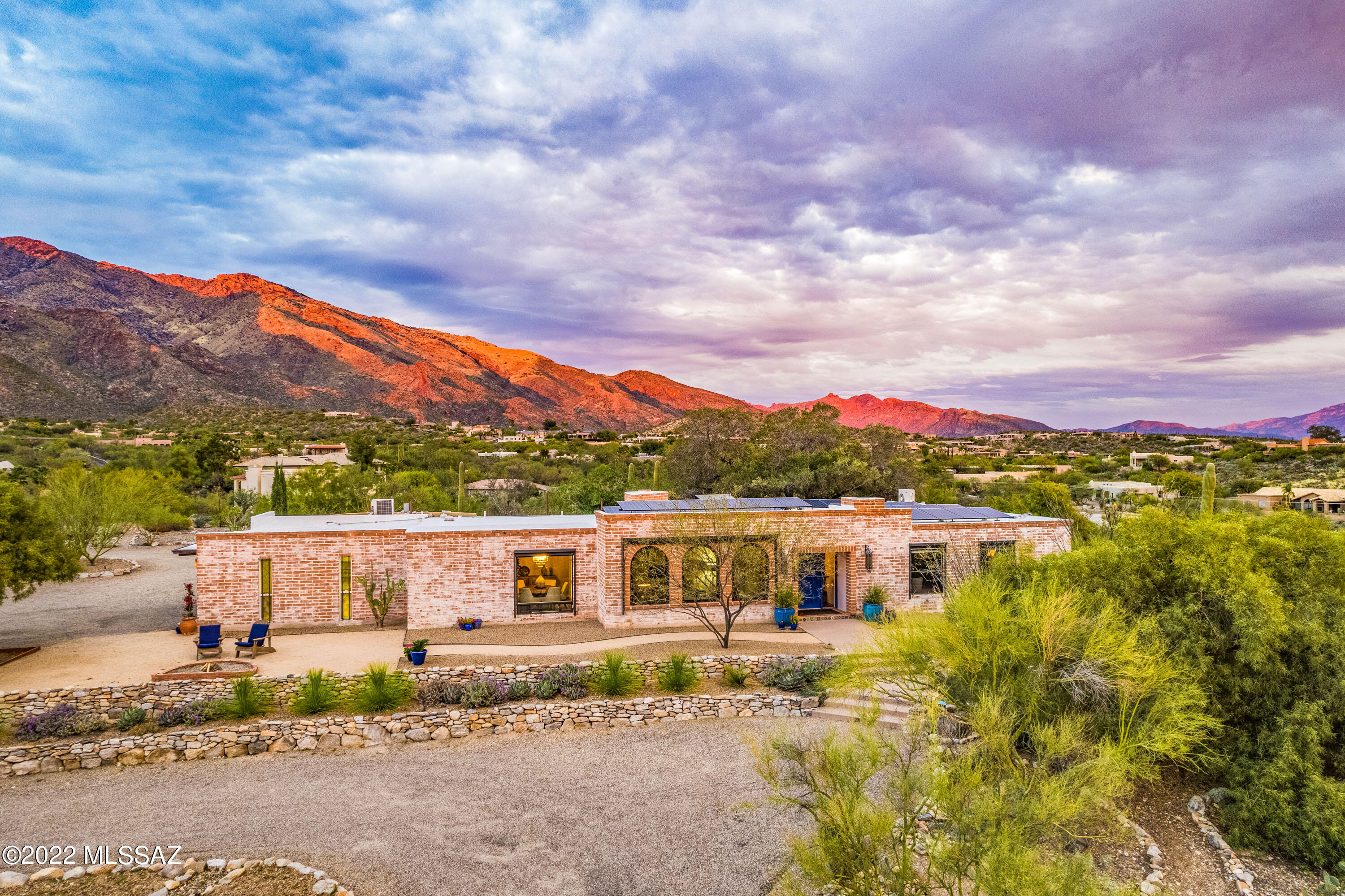 Spectacular city & mountain views form the backdrop of this wonderful burnt adobe territorial at the top of Skyline Bel Air Estates, featuring an incredible rear yard with a resort-like pool, spa & grotto that's like a stay-caytion at home.  Enter into a terrific floor plan featuring beautiful plank flooring, formal living & dining rooms, charming family room, open kitchen with bar seating, ATTACHED GUEST QUARTERS, romantic owner's suite with f/p, knotty alder doors, Fresco Harmony interior walls, SOLAR, incredible views all framed by Anderson windows & so much more.  Gas prices got you down?  ELECTRIC VEHICLE 60 AMP LINE to garage. This home has been loved & it shows.  SEE DOCUMENTS FOR ADDITIONAL DETAILS.   Mirrors are excluded from sale