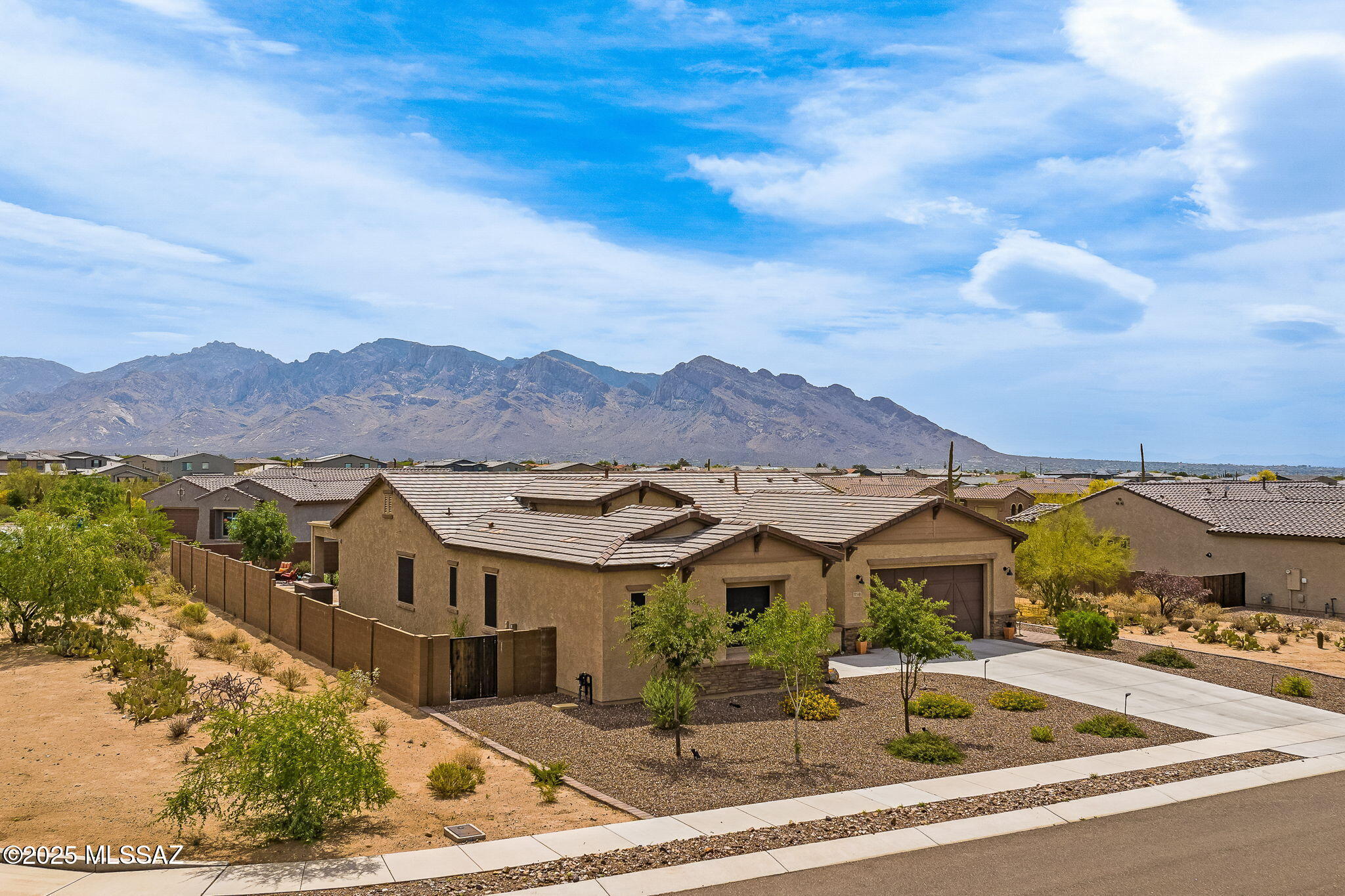 Don't miss this absolutely stunning home in the exclusive La Mirada gated community in Oro Valley! Recently constructed in 2021 by Pulte Homes, this ever-popular Rockledge model features 3 bedrooms, 2.5 bathrooms, a separate den/office, ample natural light, and tasteful touches throughout. You will find an abundance of upgrades, such as the custom iron front security door, whole home water softener and RO system, plantation shutters and remote-controlled blinds, built-in office cabinetry, and extensive landscaping. The dream kitchen boasts high-end Kitchen-Aid appliances including double ovens, 5-burner gas cooktop and range hood, microwave, and dishwasher, along with a vast walk-in pantry, soft-close cabinetry, and an oversized island with breakfast seating. Out back, relax and soak up the breathtaking views of the Santa Catalina Mountains under the spacious covered patio, around the built-in gas firepit, or with in a dip in the soothing hot tub. The home is situated on an expansive corner lot within the gated community, which allows for plenty of space between you and your neighbors. Both Wilson K-8 School and Ironwood Ridge High School are just a short walk away. Welcome home!