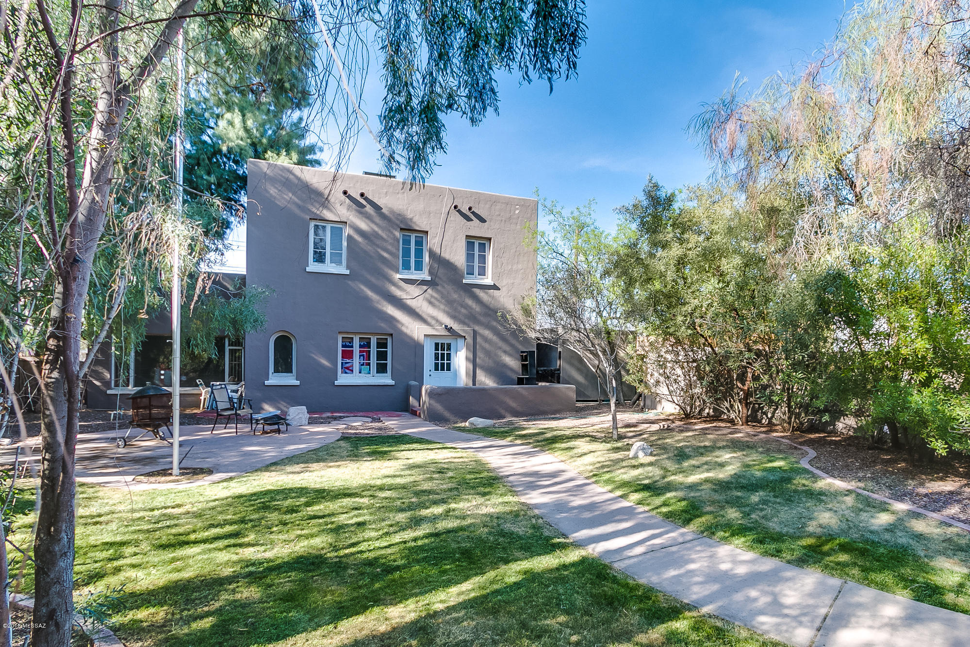 REMARKABLE 1934, 2 Story Home with a LOCATION that can't be beat.  This house is tucked away in your own private sanctuary which is full of large trees and green grass - it's your own calming oasis to sit and relax.  The home has incredible hardwood floors throughout, A/C, two BR's that open to upstairs outdoor terrace with an amazing view of the mountains, dining room, kitchen and two large living rooms (one can be a guest suite or 4th Bedroom).  Parking in back and in the front. UMC, tram stop for downtown and 4th ave, and Uofa are just blocks away.  Don't Miss making this Historic Gem your new Home!