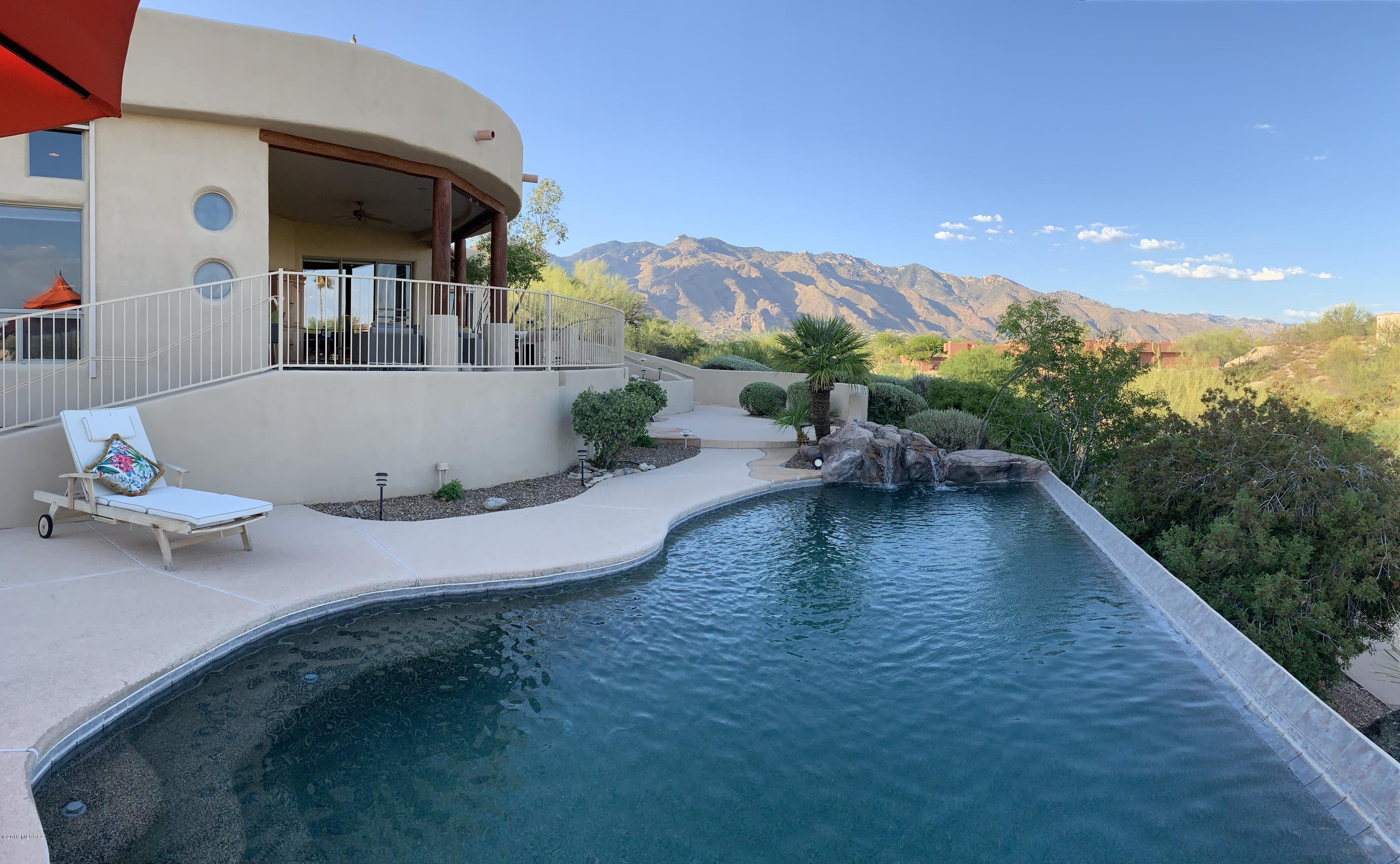 Enjoy breathtaking panoramic SUNSET, SUNRISE, MOUNTAIN & CITY VIEWS in this exquisite estate where elegance meets entertainment.  A negative edge pool invites you into 4,103 SQFT of luxury elevated on 1.42 acres located in the highly desired Cat 10 gated community.  Location is everything!  This estate boast high-end cabinetry, SubZero and Wolf stainless steel appliances, granite countertops, wood beam lined cathedral ceilings, a personal back patio putting green, outdoor fireplace, wet bar with an open concept of indoor-outdoor living, 4 bedrooms 3.5 bathrooms with an optional quest quarters containing separate outdoor entry, media room with built-in surround sound and SO much more!  Click ''View Virtual Tour Link'' below for a 3D tour. Don't miss out on this glorious home in the Catalina Foothills! Make your move and book your showing today! This gem is sure to impress!
