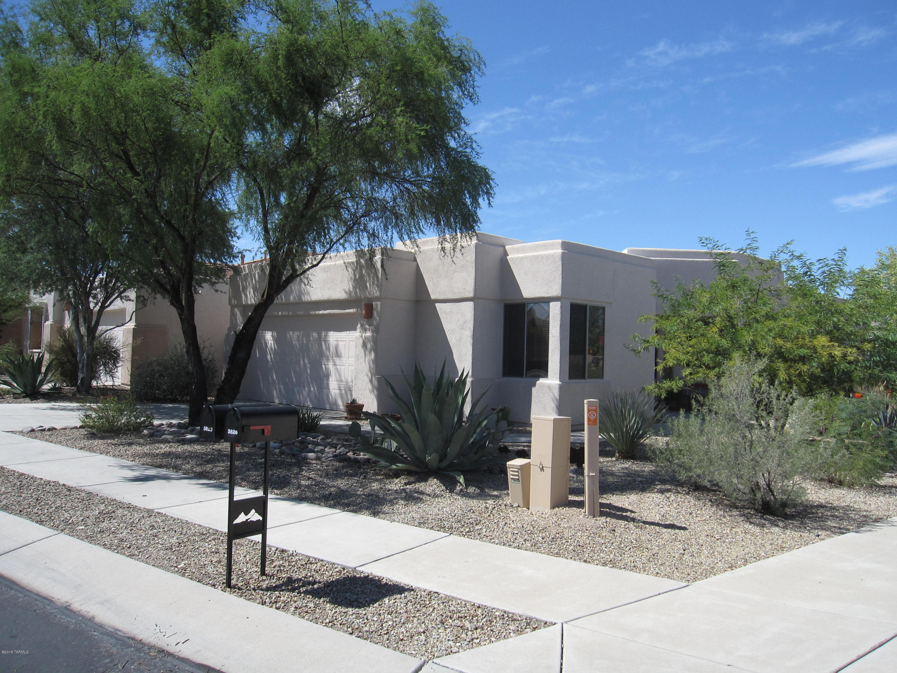 Don't miss this beautifully updated home in the upscale west side gated community of Sweetwater in The Foothills with stainless steel refrigerator and additional cabinetry and counter space in kitchen. Property has been lovingly maintained, and has glass door cabinets under breakfast bar for even more storage. Flooring is entirely tile for easy cleaning, and maintaining and there is a custom kiva gas or wood burning fireplace in living room for those cool desert evenings. Backyard backs up to large green belt area for added privacy and there is a large extended covered patio for great outdoor entertaining. Yard is large enough for pool and has some mature fruit trees. French doors in Master bedroom open to covered patio.