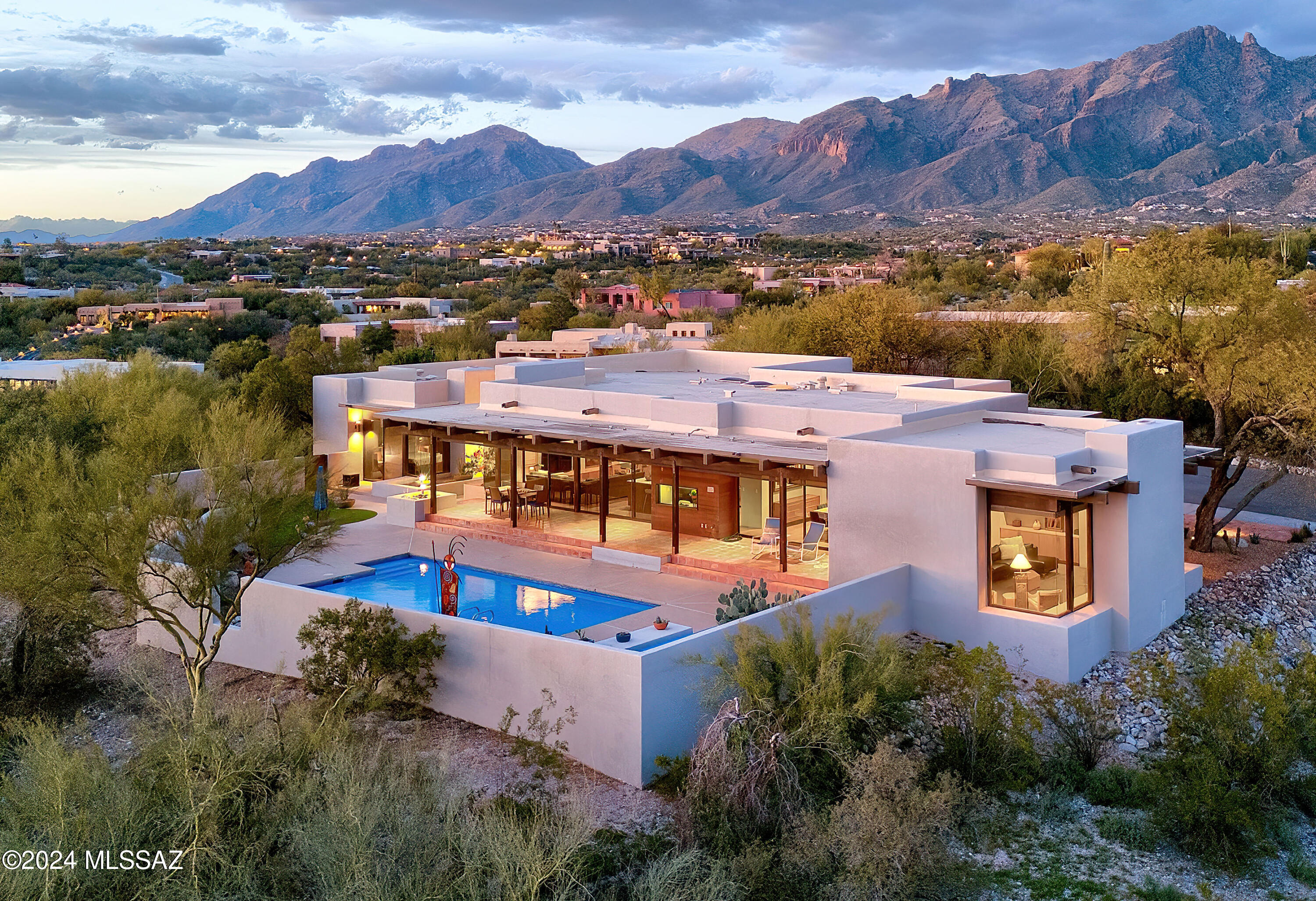 Stunning architect designed soft  contemporary,1.3 ac. ridgetop homesite w/majestic city & mt. views in prestigious gated Catalina Foothills Est.#10. Exceptional home w/ long private driveway & sparkling entry fountain.  exquisite living rm w/ dramatic floor to ceiling windows, 11ft. Douglas fir beam ceilings, fireplace, formal dining rm w/built-ins, wet bar, gourmet island kitchen w/quartz countertops, Miele SS appliances, dbl ovens, pantry, breakfast area, family rm w/fireplace, tile floors, 3 bedrooms + study/exercise rm, 3 baths, primary bedroom w/sitting area, fireplace, lux. bath, large walk in closet, laundry rm & oversized 2 car garage w/storage rm. Enjoy gracious outdoor living w/ covered patio, gas heated 30'x14' lap pool, turf, lush landscaping, fab views & Dist. 16 schools.