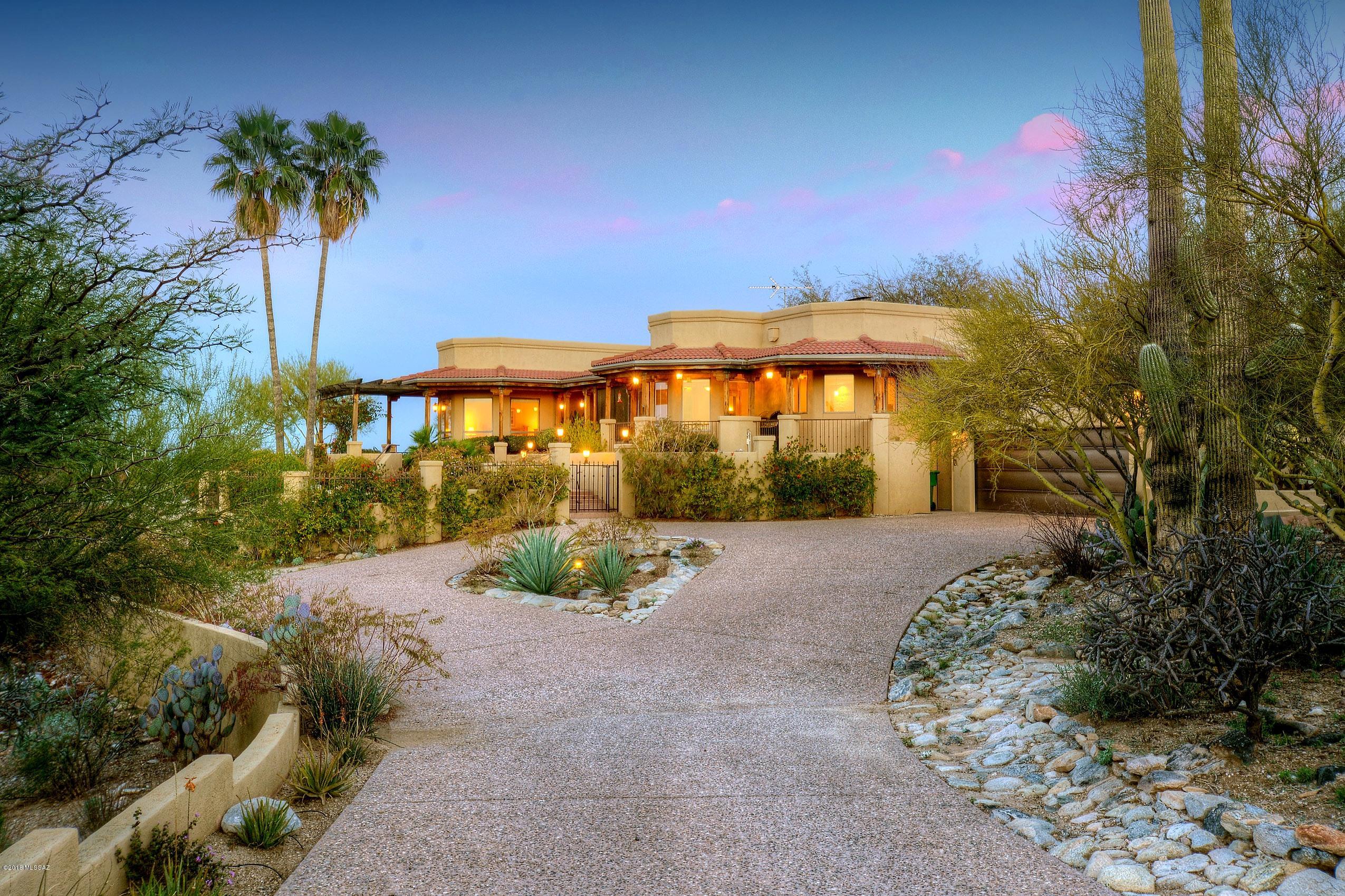 The jaw dropping, awe inspiring panoramic city light views from inside & out of this special contemporary SW style home are just the beginning. Upon entering the gracious foyer, you'll be wowed by the travertine floors, cove ceilings & clearstory windows. Both the grtrm & living area offer stunning wood beamed ceilings & 2-way fireplace for cozy evenings. Gourmet kitchen has lovely granite, dbl ovens, & gas cooktop. Formal dining room + brkfst nook with more amazing views - on a clear day you can see all the way to Mexico! Two master suites offer more views, dual sinks & cedar closets. Amazing patios, ramadas & screened in porches for wonderful outdoor living. Attached RV garage for all your toys could hold up to 4 cars, don't miss the finished basement perfect for media rm.