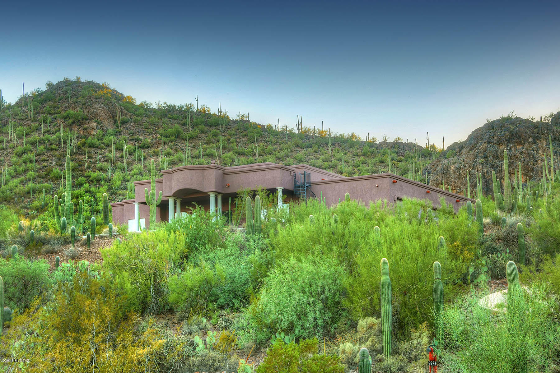 Spectacular custom home on privately gated gorgeous view lot w/sweeping mountain range & city views on 3.3 acres adorned w/hundreds of majestic saguaros. Seller's construction cost exceeded $1.2m, & quality throughout is visible; features include 1500 sq ft 5-car garage, open floor plan w/cathedral ceilings, huge windows framing the views beyond, generous entertainer's kitchen w/seating bar, luxe countertops & large storage pantry. Split bedroom plan includes lovely master w/dual baths, home office that can double as a guest or workout room & boasts a wonderful wet/dry sauna. Outdoor living features include deep shaded patios, beautifully landscaped rear yard w/fire pit & built in bbq w/seating island, & custom spiral staircase to an engineered observation deck w/even more dramatic 360 degree views.