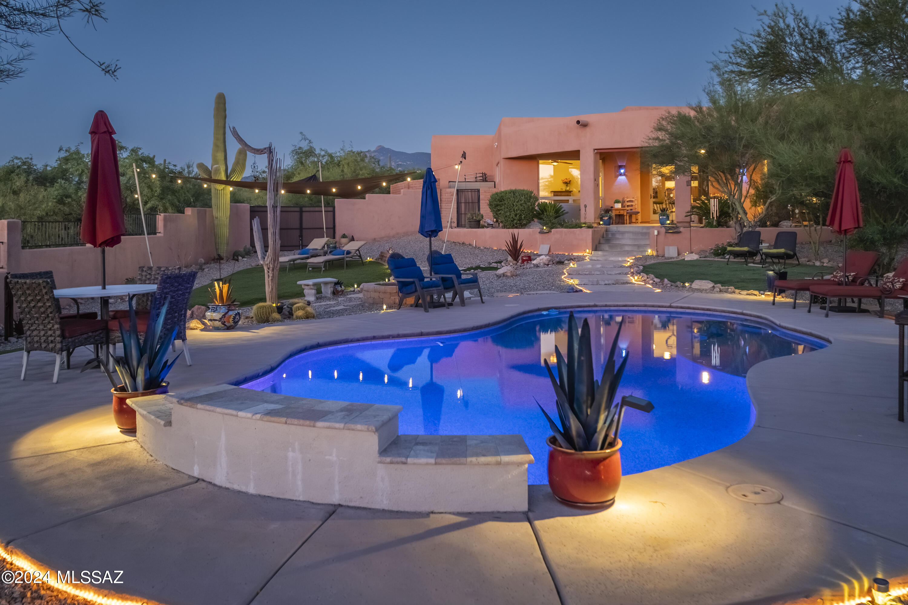 Welcome to The Sanctuary in Coyote Creek, where privacy abounds. This resort-style, custom home is located in an exquisite gated community that features an equestrian center, riding trails, and a recreation center only minutes away from town. Surround yourself in the serenity of a gorgeous desert landscape with panoramic mountain views and picturesque painted skies from the front courtyard, the living spaces, or the masterfully designed backyard oasis. Step into a home with soaring ceilings, stunning Southwestern design elements, handmade shiplap walls, and walls of wood-framed windows that create the feeling of being connected to the outdoors. The oversized kitchen offers so much with a plethora of knotty alder cabinets, expansive granite counters, stainless steel appliances, a wine fridge, and mesmerizing views from the window. Relax in the Owner's Suite with even more views, a spa-like shower, and direct access to the back patio, pool and spa. Need storage? There is a large storage space above the laundry room, and the 3-car garage fits oversized trucks and is outfitted with plenty of cabinets as well as workshop space. Warm up by the wood-burning fire-pit outside, or cool off inside where the HVAC system was recently replaced. Newer water softening system, hot tub, kitchen fridge, laundry machines and deep freezer all convey with acceptable offer. Come. See. Stay!