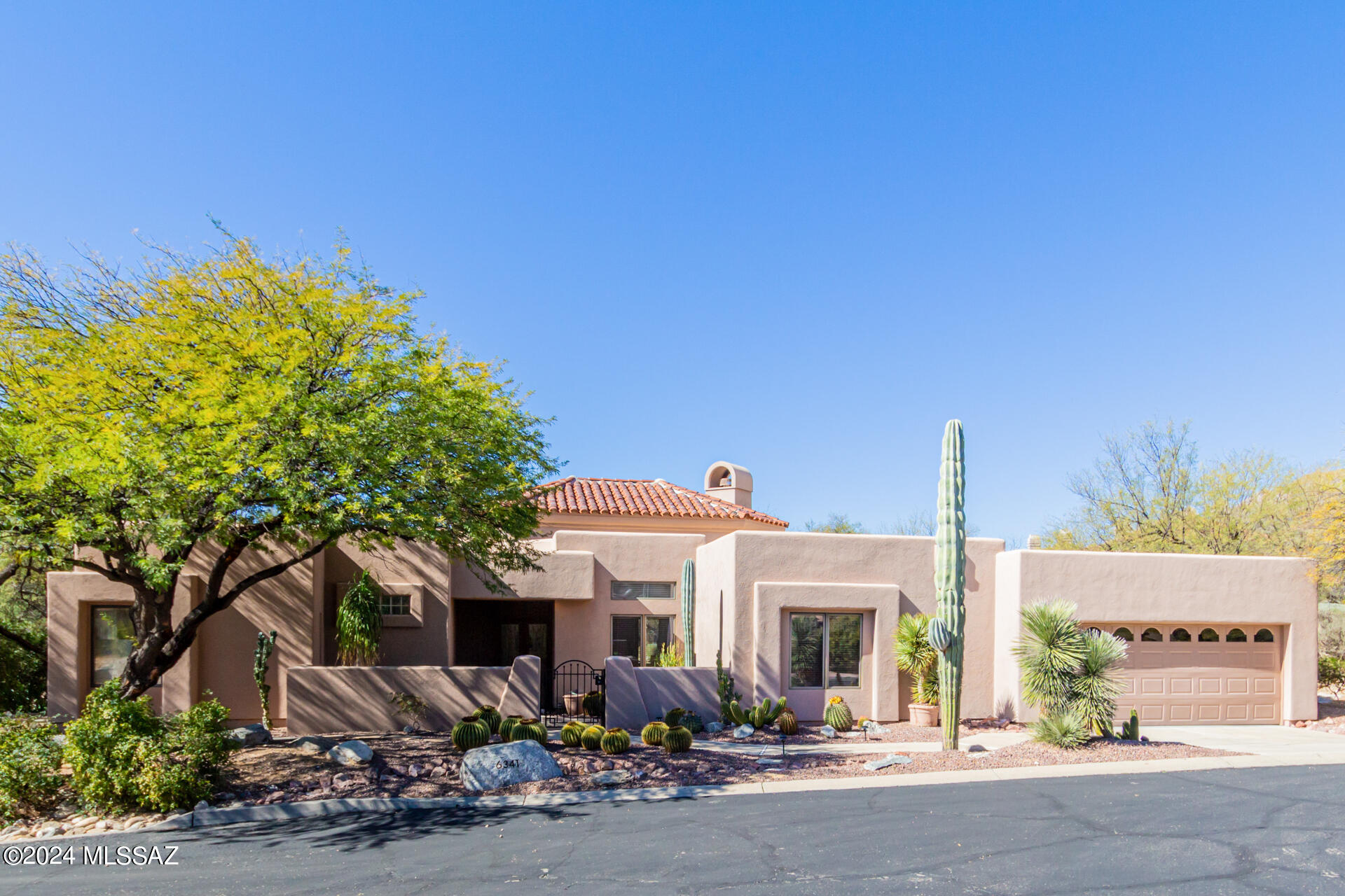 Beautifully maintained casually elegant home in Ventana Canyon exuding quality throughout. Enter the private courtyard and attractive security doors into the open foyer.
''Let there be light!'' Stunning living room showcased by Viga beamed tongue-in-groove vaulted knotty pine wood ceiling, 360 degrees of skylights, and a warming Kiva gas fireplace.
Attractive Saltillo tile in entry, kitchen, breakfast area, laundry and baths and Berber carpet in the living room, bedrooms, and den.
Culinary enthusiasts will delight in the fabulous island kitchen well equipped with built-in microwave, electric cooktop, handy pantry cabinets, convenient breakfast bar and dining  rea, and an abundance of cabinets and neutral countertops. 
The spacious primary suite providing a built in storage bench not disappoint! Stylish French doors open to a portion of the back patio that can become a completely private area for workout, hobbies, etc, by closing in 3 sides operated with remote controlled garage doors.  Ensuite features separate shower, soaking tub, power shades for natural light and privacy, convenient open shelving, and a large walk in closet.
Laundry room offers ample cabinets, Maytag washer and dryer, and handy laundry sink. Oversized 2 car garage boasts a wall of storage cabinets, an additional refrigerator, water softener, and durable epoxy floors. Lovely EZ care backyard with kiva fireplace, extended covered porch and patio, and all highlighted by brick pavers offers excellent spaces for quiet moments or entertaining family and friends. HOA provides 24 hour manned gates, common area landscape, street, and sewage line maintenance, and includes trash pickup. 
Minutes from Ventana Canyon Resort and Country Club, fine shopping, popular restaurants, and highly rated Catalina Foothills schools.