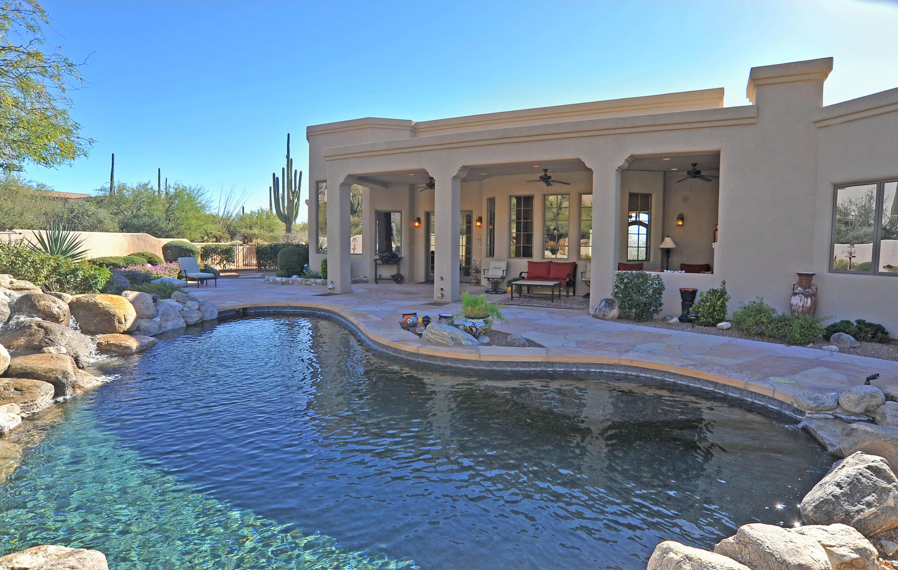 Located on a corner lot in Pima Canyon upper gated area (Sunset Gardens) w/ coveted Pima Canyon views. Fine Tuscany touches and amenities. Beautiful walnut floors, 2 wood burning fpls. Large open great room with lofty ceilings and gourmet kitchen with granite, stainless steel appliances, fine alder cabinetry and doors and large open picture windows showcasing the views and beautiful backyard featuring spa, pool and water features.  Outdoor living area with corner fpl, boncos, and fire pit with low care lush landscaping. Several covered patios with private entrances. Large workshop is unique to this home with upgraded electric and sink or double as an art or exercise studio with separate entrance plus oversized 4 car garage. Absolutely no steps. OVER THE TOP HIDDEN QUALITY.