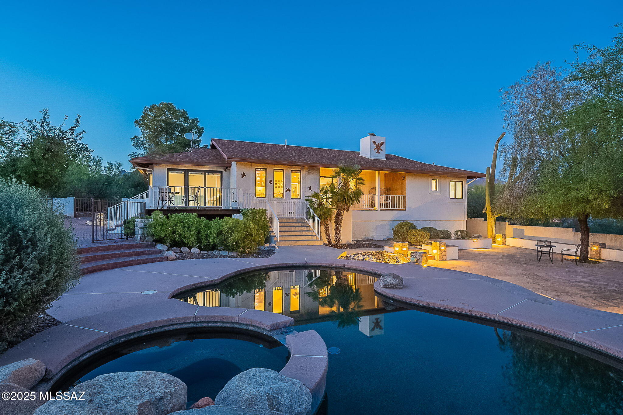 Outstanding indoor-outdoor living in Shadow Hills -- nestled on a prime interior cul-de-sac lot, offering a rare combination of two-way views, expansive outdoor entertaining spaces, and floor plan perfect for both hosting and privacy... all in a not-too-big house. Outside, a front courtyard with mountain views, two elevated rear decks with views to the south, a fantastic pool, and a huge flagstone patio shaded by trees..and buffered by an impressive amount of walled yard and a natural wash on one side. Inside, bright and airy living spaces surrounding a chef's kitchen, and a split-bedroom floor plan with a large primary suite feels just right. All in all, a great value for one of the most sought-after neighborhoods in Tucson. See ext'd remarks and video and virtual tour Nestled on a superb interior spot in Shadow Hills, this property stands out.  The outdoor spaces here are hard to find anywhere else on the market at this price point, not to mention in a premium neighborhood like Shadow Hills.  Entering into the semi-private front courtyard, one immediately gets a sense of seclusion and intimacy.  With a large (350sqft) paver patio, a smaller shaded deck, and terraced levels for planting, the courtyard is bordered by greenery on several sides, forming a special spot for welcoming guests and a shaded area for entertaining late in the day in the summer, or a sunny spot for mid-day relaxation in the cooler seasons.  Best of all are the dramatic mountain views.

The interior features open living spaces wrapping around the kitchen, with a living room featuring lofted wood beam and plank ceilings and a dramatic stone fireplace on one side, and a light-filled family room on the other, brightened by a large bay window.  Between is a dining space with wet bar, perfect for entertaining.  All enjoy southern exposure and views over the huge walled back yard toward A Mountain in the distance -- one of the relatively few spots in Shadow Hills that enjoys southern views.  The kitchen is set up around a work triangle made for cooking and hosting, and with a large granite-topped peninsula with a gas cooktop and room to seat four.
  
Having the two living/entertaining areas (living room on one side, family room on the other) is perfect for hosting family gatherings or parties, or for when people might want to be enjoying two different things at once (movie in one room, game or conversation in the other.)   

The split bedroom floor plan is a great set up, with the primary suite off on its own on the east side and the other two bedrooms down the hallway on the north.  The primary suite has plenty of room to spread out, with an area on one side perfect for a study or office-type area, exercise/yoga, or just for sitting and reading and enjoying the greenery overlooking the front courtyard through the huge picture window.  Not to be overlooked are the two walk-in closets, each spacious themselves.  The secondary bedrooms are great for full time use as bedrooms, or as office, den or craft room.  

The two car garage features a bonus space currently set up as a workshop, with workbenches, cabinets, and storage shelves, but could just as well be space for a home gym.

Outdoors is where this property truly stands out.  Walking out from the living room there's the covered porch, large enough for lots of seating, whether as an outdoor living room or dining space.  On the other side, outside of the family room, a wooden deck with views of A Mountain.  Down the steps on either side are plenty of entertaining spaces on three levels, from the pavered patio on the west side, down to the pool deck, and finally the huge flagstone patio (over 1200sqft itself).  Beyond those already established entertaining areas, there's a huge amount of space inside the perimeter wall and could be the place for anything, really... raised garden beds next to the house...a pickleball court... planted out to be a desert oasis... so many possibilities.  

All in all, a fantastic combination of elements in an incredible spot in one of Tucson's most sought-after neighborhoods.