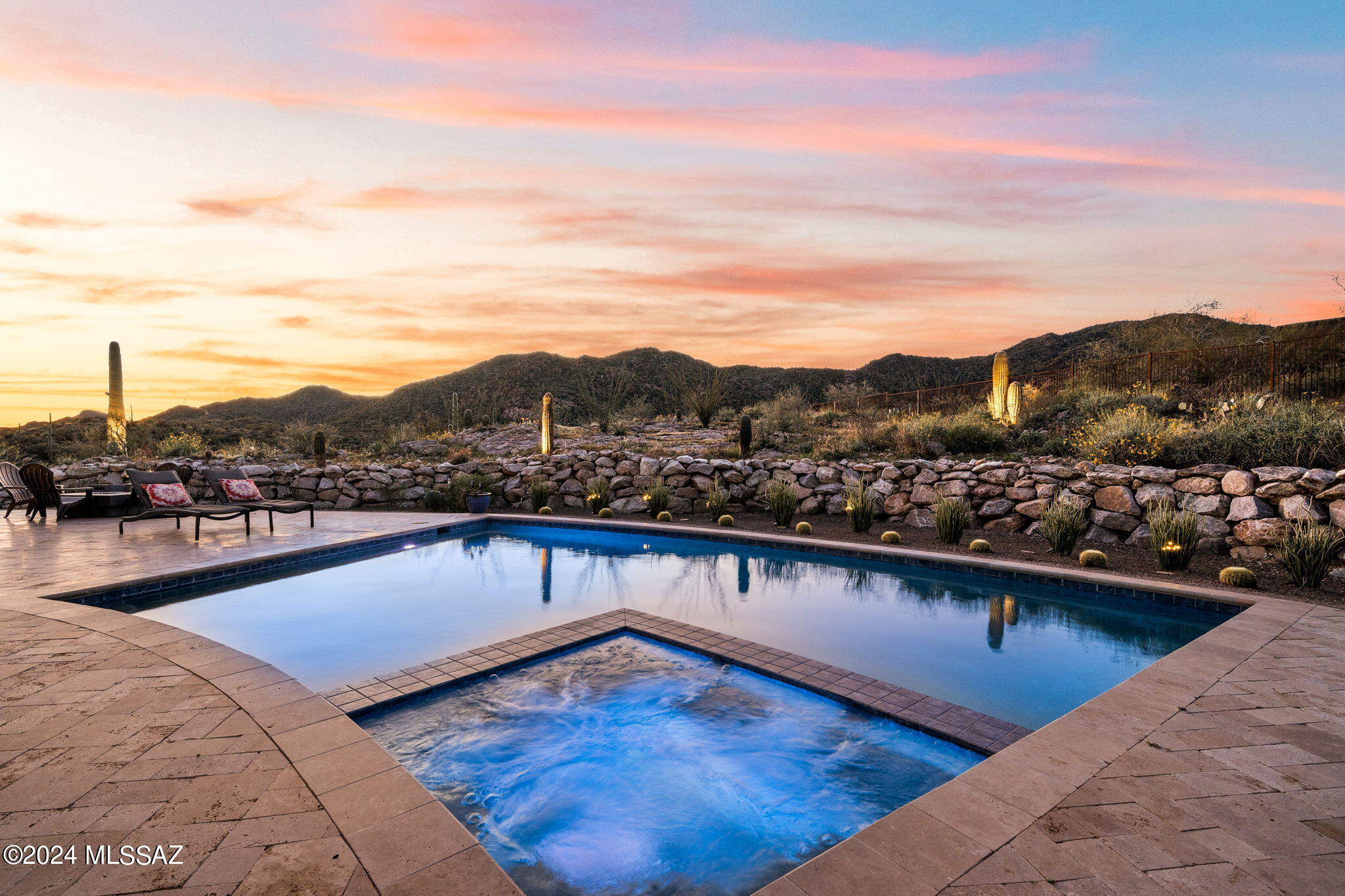 Step into a symphony of sophistication and serene beauty with this Santa Barbara-inspired home. Located in the prestigious guard-gated community of Stone Canyon, this dreamy home offers a masterful blend of luxury and tranquility. Crafted with meticulous attention to detail, this 4,158 sq ft. residence on a 1.032-acre lot that gazes out over the lush Tortolita Mountains. Framed by a vibrant desert tapestry dotted with majestic saguaros and Arizona's star-filled nights, retreat to the privacy of your sparkling pool/spa. Each room is a testament to refined taste, with bright, airy compositions that highlight the home's connection to the stunning landscape outside. Four bedrooms, Three with an enclave of privacy with its ensuite. Owners are licensed to sell real estate in Arizona and Utah. The unique artistry is apparent from the moment you approach the bespoke front door entry door, opening to a world of refined elegance with soaring 14-foot ceilings in the great room, all under the watchful grace of radius wall of view windows, and warmth of a gas log fireplace.
Spanning a generous layout, a gourmet kitchen is a chef's dream, featuring top-of-the-line Wolf appliances, a Sub-Zero wine cooler, and sumptuous Blanc du Blanc granite countertops, making culinary creation a joy in this artful setting.
Residents of Stone Canyon enjoy exclusive access to a wealth of amenities that underscore the community's commitment to a high-quality lifestyle. The 25,000 square foot clubhouse, a sanctuary of social and recreational pleasures, sits proudly behind the 18th green, offering sweeping views of the fairway and the Santa Catalina Mountains. Facilities include luxurious locker rooms, a well-appointed golf shop, and versatile dining venues that range from cozy indoor bars to a vibrant outdoor bar with a fire pit, all designed to enrich the lives of those who call this community home.
Granite Peak Place is a private retreat, offering a tranquil, grounded lifestyle that is in perfect harmony with its luxurious setting. Schedule your private tour today!