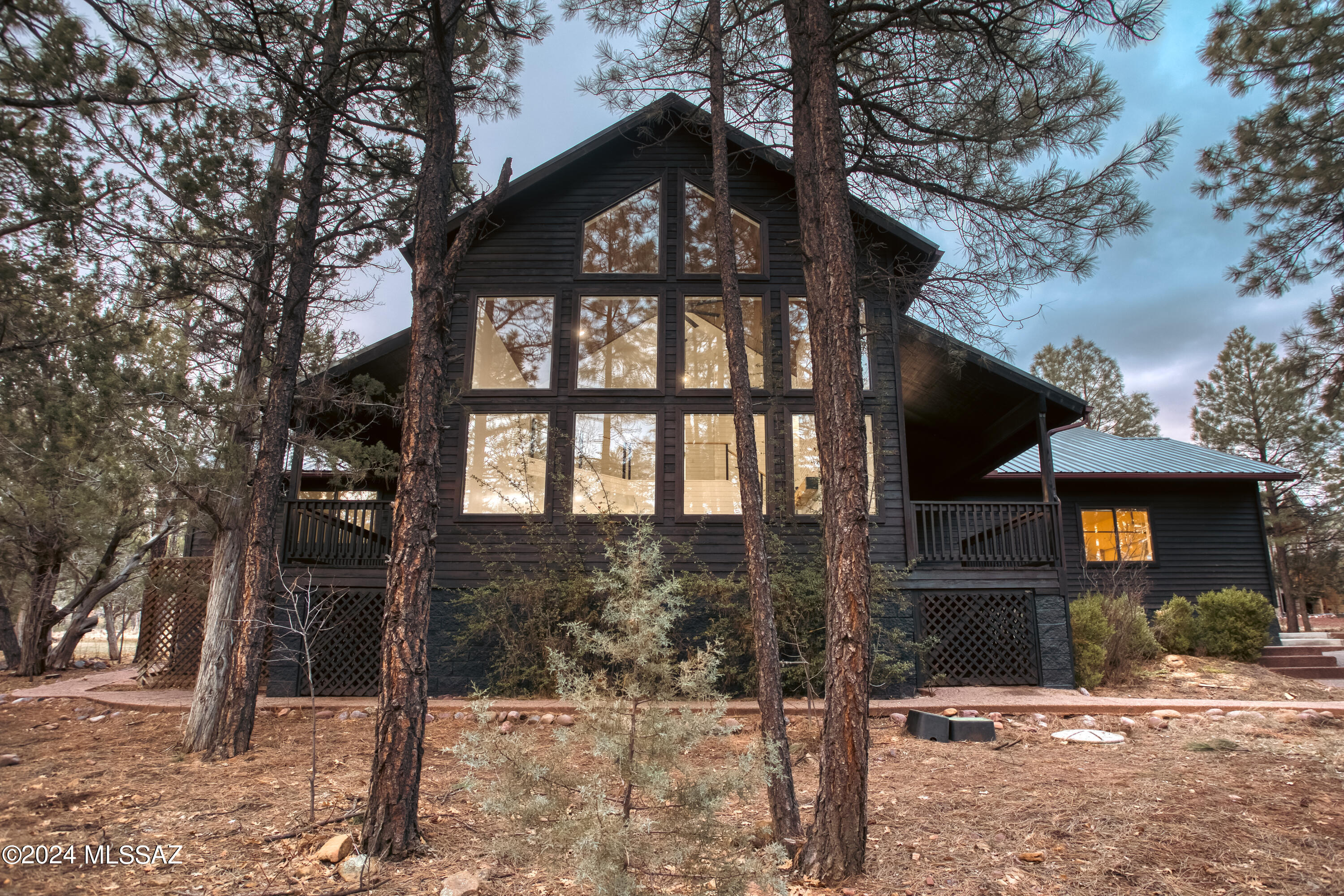 Experience the epitome of mountain luxury in this completely remodeled Sierra Pines Cabin, nestled on over an acre of densely forested land in Show Low, Arizona. Redefining comfort and elegance with a professional and thoughtful redesign, this cabin unveils a modern floor plan that includes a newly added fourth bedroom and a convenient walk-in pantry, enhancing both space and functionality. The heart of the home is the kitchen, where quartz countertops meet custom maple dovetail cabinets, creating a harmonious blend of style and craftsmanship. The Cafe style stainless steel appliances provide a gourmet experience for the home chef, while the new lighting and plumbing fixtures throughout the cabin add contemporary flair to the rustic setting. Central to the living area, a German... Experience the epitome of mountain luxury in this completely remodeled Sierra Pines Cabin, nestled on over an acre of densely forested land in Show Low, Arizona. Redefining comfort and elegance with a professional and thoughtful redesign, this cabin unveils a modern floor plan that includes a newly added fourth bedroom and a convenient walk-in pantry, enhancing both space and functionality. The heart of the home is the kitchen, where quartz countertops meet custom maple dovetail cabinets, creating a harmonious blend of style and craftsmanship. The Cafe style stainless steel appliances provide a gourmet experience for the home chef, while the new lighting and plumbing fixtures throughout the cabin add contemporary flair to the rustic setting. Central to the living area, a German...

...Schmear fireplace stands as a testament to exquisite design, offering a cozy ambiance and a stunning focal point. The second level soars with vaulted ceilings, amplifying the cabin's spaciousness and reinforcing the grandeur of mountain living. Protecting this treasure is a new 50-year metal roof, promising durability and peace of mind. Beneath your feet, luxury waterproof flooring offers both beauty and resilience against the elements, ensuring your home remains a sanctuary of comfort no matter the season. Outside, the sprawling land is a canvas of nature, with majestic trees that whisper tales of serenity and seclusion. This cabin does not just offer a home; it promises a lifestyle ensconced in the beauty of Arizona's high country and adventure.