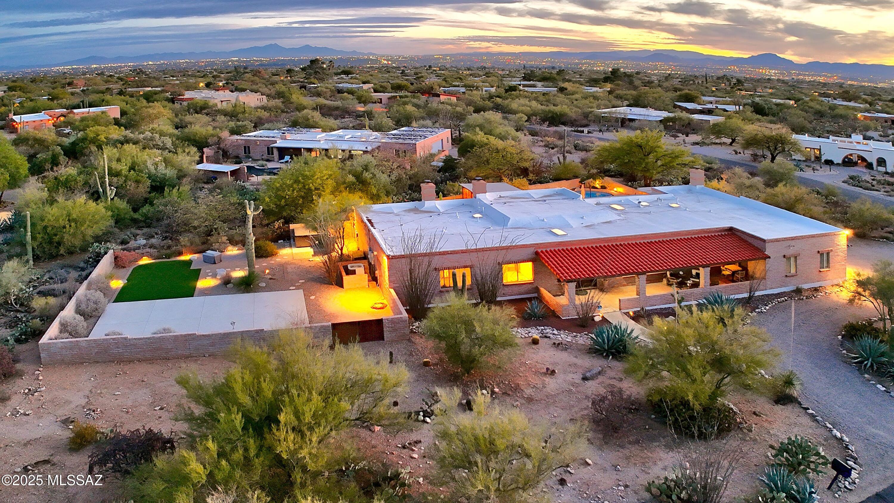 This impeccably updated classic Tucson Territorial home showcases sunset & mountain views, a dream backyard and sophisticated modern enhancements at every turn. Step inside thru the double door entry to find a spacious family room w/exposed adobe, beam ceilings and cozy FP. Gorgeous kitchen has been remodeled w/sleek cabinetry, elegant quartz counters, marble island & Café appl. Sep living & dining areas w/north facing mtn views. Sprawling primary retreat w/FP, Lg walk-in closet, dual sinks & walk-in shower. 2nd primary has lovely FP, updated bath & is ideal for guests. Immaculate resort-like bkyd has sparkling pool, ramada, firepit, pizza oven, fountain, turf area & sport court all set against a stunning mtn backdrop. This exceptional home blends timeless SW character w/modern luxury!
