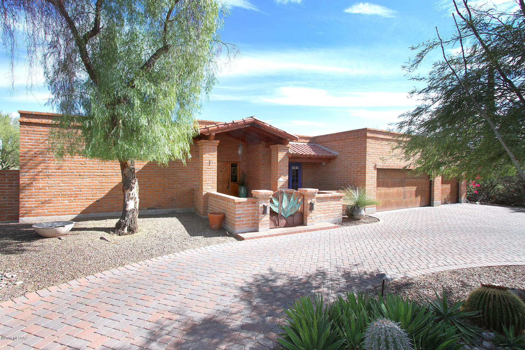One-of-a-kind home offers stunning Catalina Mtn views, privacy & all the character/charm befitting the SW. Soaring beamed ceilings, wood plank & Mexican tile floors, arched entries, copper clad niches, hand-painted Talavera sinks & custom colors thruout. Large living spaces are kept light by numerous skylights, french doors & windows to bring the spectacular landscaping & Mtn views in. The kitchen provides gorgeous granite counters, tons of storage & a breakfast bar in addition to the eating area. The focal point of the large family rm is the floor to ceiling brick fireplace & bonco surround. Private luxurious master suite. Multiple plank & beam covered brick pavered patios thruout. Resort-style grounds feature pebble tec pool w/water feature, lush landscaping, privacy & stunning Mtn views