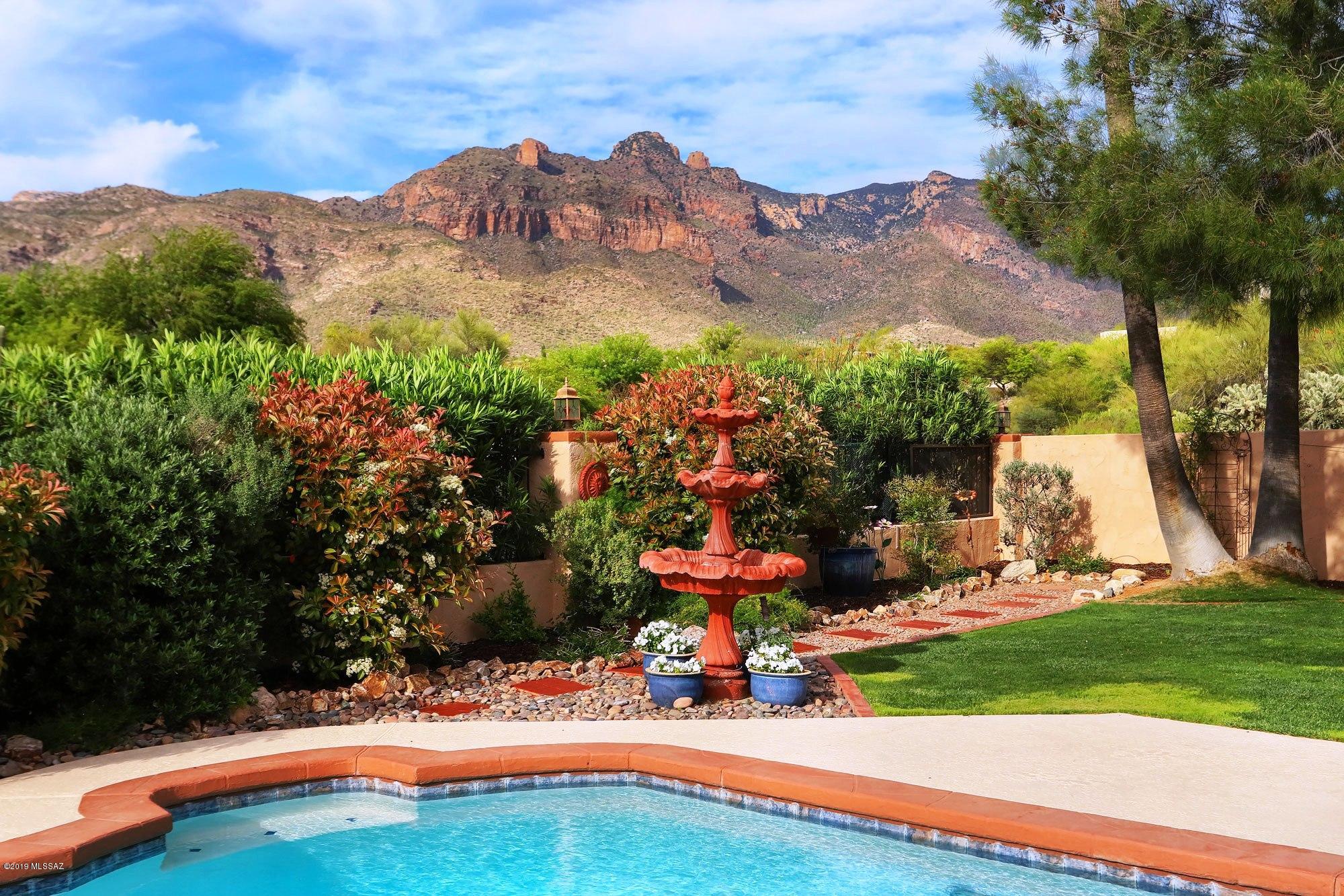 Run don't walk to this gorgeous remodeled Catalina Foothills  home with fabulous mountain views, surrounded by lush vegetation and boasting a stunning island kitchen w/rich wood cabinetry, granite counters, SS appl & tile backsplash.  Addl interior features incl: wide open floorplan, designer tile floors thruout, awesome greatroom w/huge picture window and cozy corner FP.  The lovely & very spacious Mstr Ste has dual sinks, beautiful tile work, walk-in closet & slider out to back patio.  One of the extra bdrms has an ensuite bath and the hall bath has dual sinks and a jetted tub.  Fabulous outdoor areas incl inviting front pavered patio, enormous plush bkyd oasis w/wonderful covered porch, lawn, fountain & more amazing mtn views.  All this nestled on a very private 1.25 AC cul-de-sac lot.