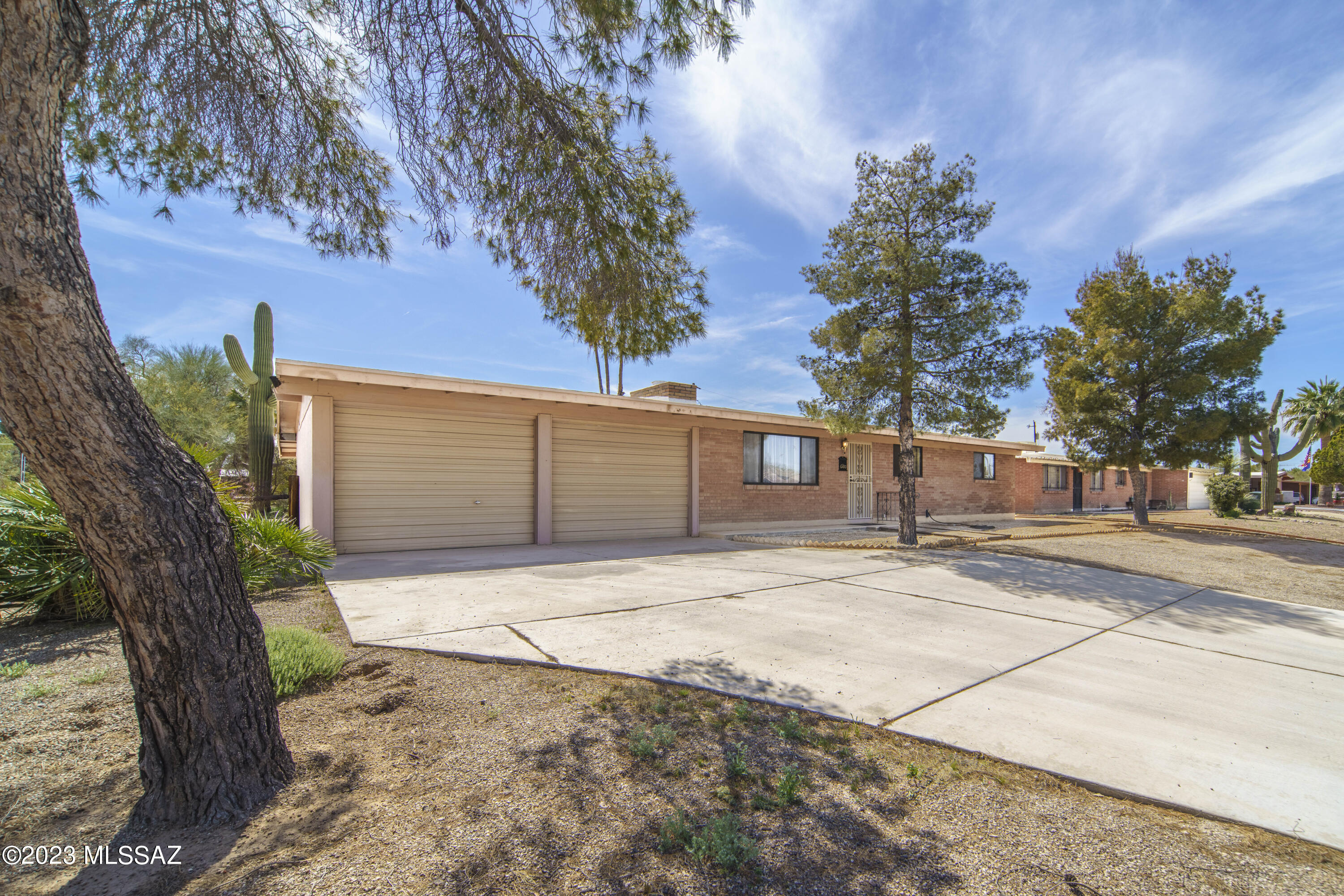 Mid-century 1963 home w/desirable brick construction.  Cozy Wood burning fireplace.  So much charm & No HOA!  Tile throughout, NO carpet! Fabulous corner lot with no neighbors to the East. Updates include: 2020 New AC Unit, Heating system & Water Heater. Main Water line replaced from curb to home. Double pane windows. Sturdy Block Wall around back of home w/large wrought iron double gate (RV's allowed). Large back covered porch with pavers. 2 Car garage w/large workshop/storage room attached. Don't miss this one.