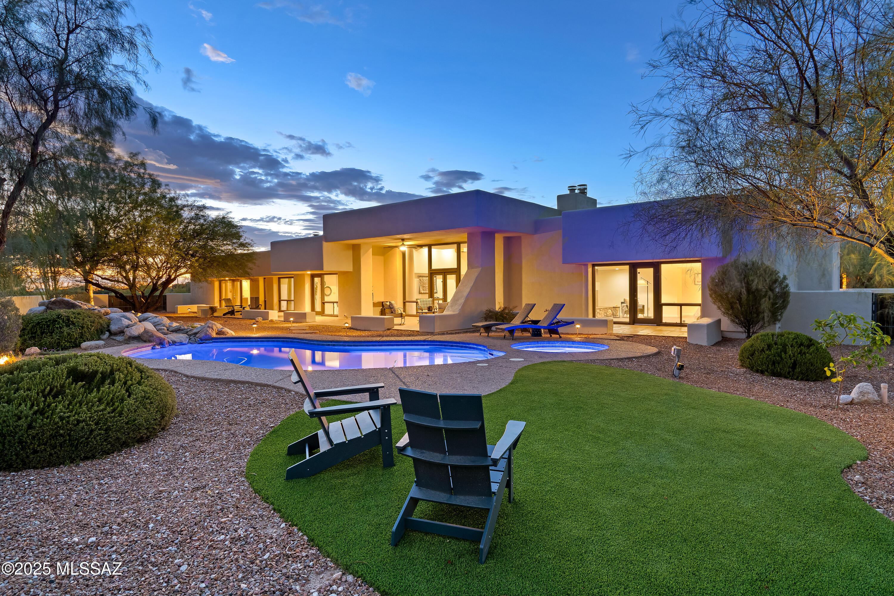 Show-stopping Desert Contemporary designed by David Tyson situated on a premium hilltop lot in the highly sought-after, guard-gated Catalina Foothills Estates 10. Spanning over 4,900sqft, this impressive split-bedroom floor plan offers two primary suites and three generously sized guest beds/baths; each with private walk-in closets and patios. Cascading natural light throughout with floor-to-ceiling windows, remarkably high ceilings, exposed beams, 3 fireplaces, timeless finishes, a three-car garage, and no interior steps! The kitchen provides ample storage, a 48'' gas range, a large pantry, and an oversized island, perfectly suited for entertaining! Once outside, enjoy the refreshing pool/spa, serene water feature, and ample seating areas, all while taking in the twinkling city lights.