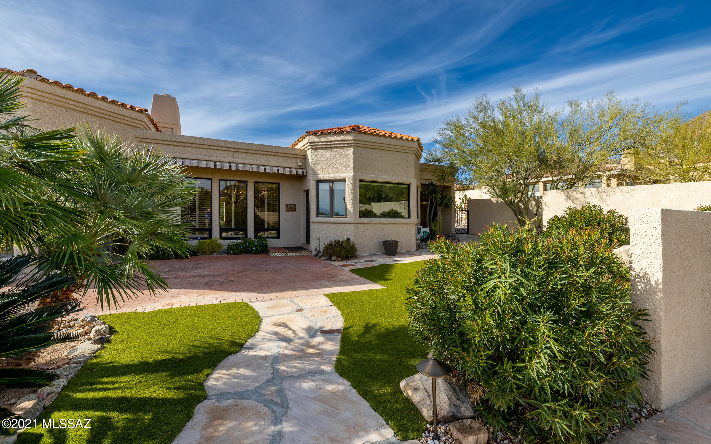 Well maintained secluded home, in Gated community,is a traditional Santa Fe inspired design.Nestled in heart of Catalina Foothills w/Mountain & city views. Floorplan & décor has many windows, Saltillo tile, wood beamed ceilings, Wine Frig, Flagstone Fireplace, Formal Living & Dining Rooms, Family Room w/custom built-ins throughout. Kitchen has large walk-in pantry, built-in desk, dining nook w/built-in hutch, newer Stainless Steel appliances; dbl wall oven, microwave, trash compactor, water filtration system & original sub-zero refrigerator. Back brick patio has entertained many graduations, weddings, & parties over the years. Custom built of block stucco, dual zone cooling of AC & evap; Mission Tile treatment to Built up roof; hidden safe, solid core doors,  &  new motor for 2-car garage