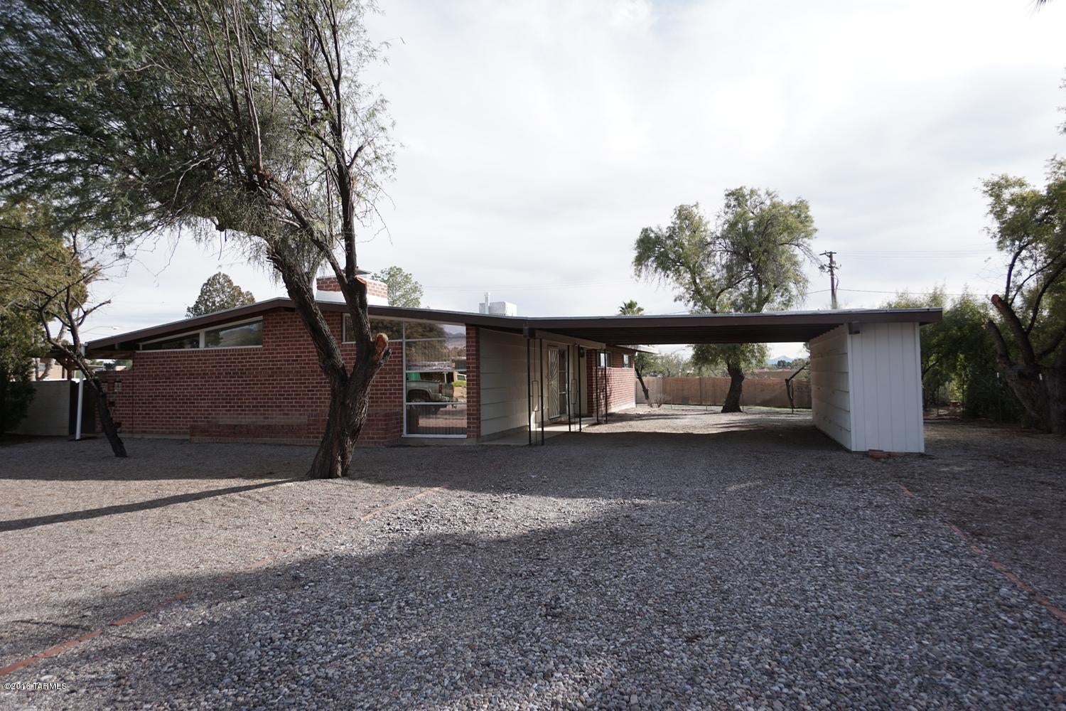 Charming 3Bed/2Bath burnt adobe home tucked away in a historic neighborhood. Located on cul de sac street. Some high ceilings, FP in living area off dining/bonus area, tile/carpet flooring. Nice kitchen with shelving in dinette area. A/C, extra storage, washer/dryer included. Covered Patio opens to large backyard. 2 car carport, Convenient to shopping, dining, in and around the Tanque Verde area. Large lot & well maintained home. Community pool option, TUDS Schools (Tanque Verde & Kolb)