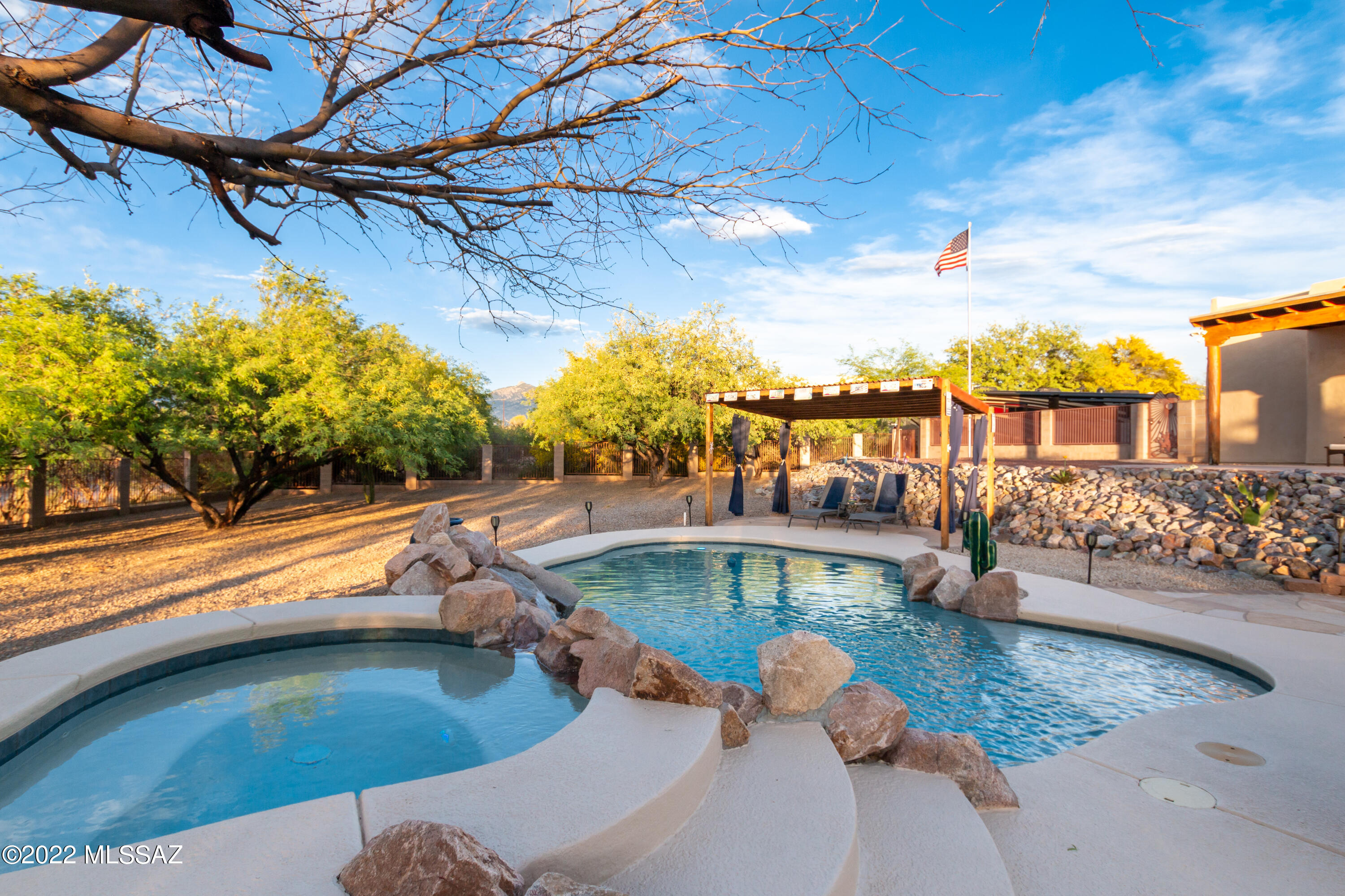 Prepared to be impressed with this beautiful custom Home!! This stunning home sits on over 1 acre with spectacular mountain views, RV parking and No HOA! Once you arrive you will notice the clean lines, easy care low maintenance landscaping and oversized 3 car garage. Through the solid wood front doors, you gain access to this easy flowing open floor plan with high ceiling, overlay concrete floors throughout, lots of skylights, plus breathtaking views of the majestic mountains as you enter the formal living and dining space. From here you flow into the gourmet kitchen which offers granite counters, large island, gas cook-top, stainless-steel appliances and large pantry. Off the gourmet kitchen you will enjoy the additional dining area, and family room with relaxing gas beehive fireplace The ideal split floor plan allows for 3 spacious bedrooms on one wing for guests with 2.5 bathrooms. The primary suite offers a large bedroom with an open bathroom featuring dual vanities, soaking tub, walk in shower and spacious closet. Now the true delight is the backyard oasis with the endless Views! This is the perfect place to truly entertain or escape and relax. From the expansive porch you will take in your sparkling pool and spa with cascading waterfall. If you can take your eyes from this, you will notice so much more. You also have your own pool cabana, built-in BBQ grill, fireplace with additional sitting area and enclosed dog run with artificial turf all wrapped up in the tranquility of the Sonoran Desert. This home will not disappoint or last. Schedule your tour today!