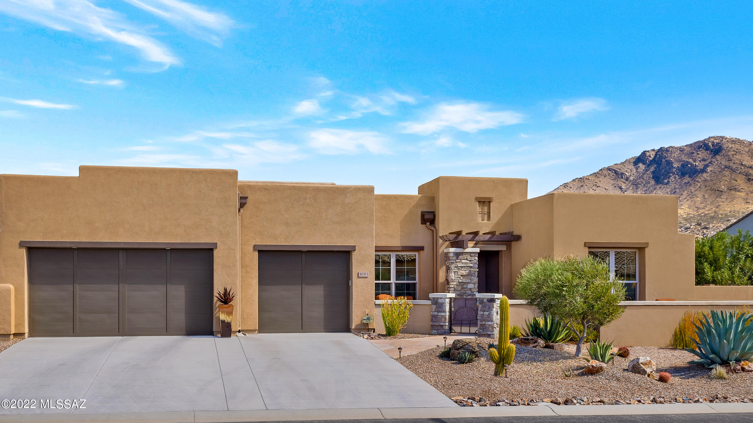 First time on the market, this ultimate desert living ''Santa Fe'' style home is located is SaddleBrooke's premier neighborhood of The Preserve. This customized house offers 2 bedroom suites. Den with double doors makes the perfect office space. Bonus room is ideal for a studio, hobby room or additional guest space. The gorgeous open floor plan w/ 12 Ft. ceiling features a built-in entertainment system and 7 speaker surround sound system. The warm inviting interior includes 8 Ft. alder wood doors that coordinate with matching trim, baseboards and exterior doors. Appreciate the beautiful tile floors, quartz counters, Hunter Douglas shades and silent ceiling fans. Step out on to the front and back patios for lovely views of the Catalina Mt.s Enjoy the built-in BBQ on the covered patio. The 3 car garage is equipped  with an electric car charger, utility sink and plenty of storage shelving. Energy saving features include remote-controlled retractable sun shades and performance HVAC system.  A central vacuum system, security system, water softener and whole house surge protector.
Inside the entry, the laser-carved backlit wall art conveys. 
Backyard wall with neighbor is in process of adding 5 more blocks high.