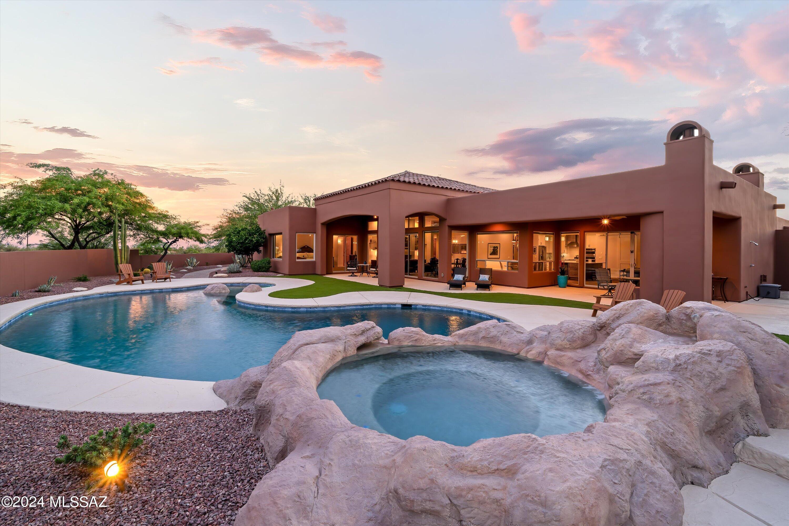 This stunning custom home is located in the exclusive gated community of The Reserve at Coyote Ridge, centrally located in Oro Valley with priceless views of the Catalinas, and situated perfectly on nearly 1 acre, slightly elevated, creating a private setting.  Enjoy the salt water pool, spa, outdoor fireplace, BBQ station and mature landscaping with multiple sitting areas to enjoy this desert oasis.  Two living areas with walls of windows, fully remodeled kitchen with large quartz island, custom lighting, farm sink, reverse osmosis, walk in pantry.  Spacious primary suite w/custom closet, coffered ceilings & fully remodeled bath.  The ensuite & hall bathrooms have also been remodeled.  This home is a must see to appreciate the detail and pride of ownership. In 2023 both furnaces and A/C units replaced, new reverse osmosis system installed, new in-house vacuum system, new irrigation system.  In 2024,  exterior of home painted, tankless recirculating hot water heater, all windows replaced in guest bedroom wing, and pool deck just refinished in June.  This home was originally built by the builder for their own home.