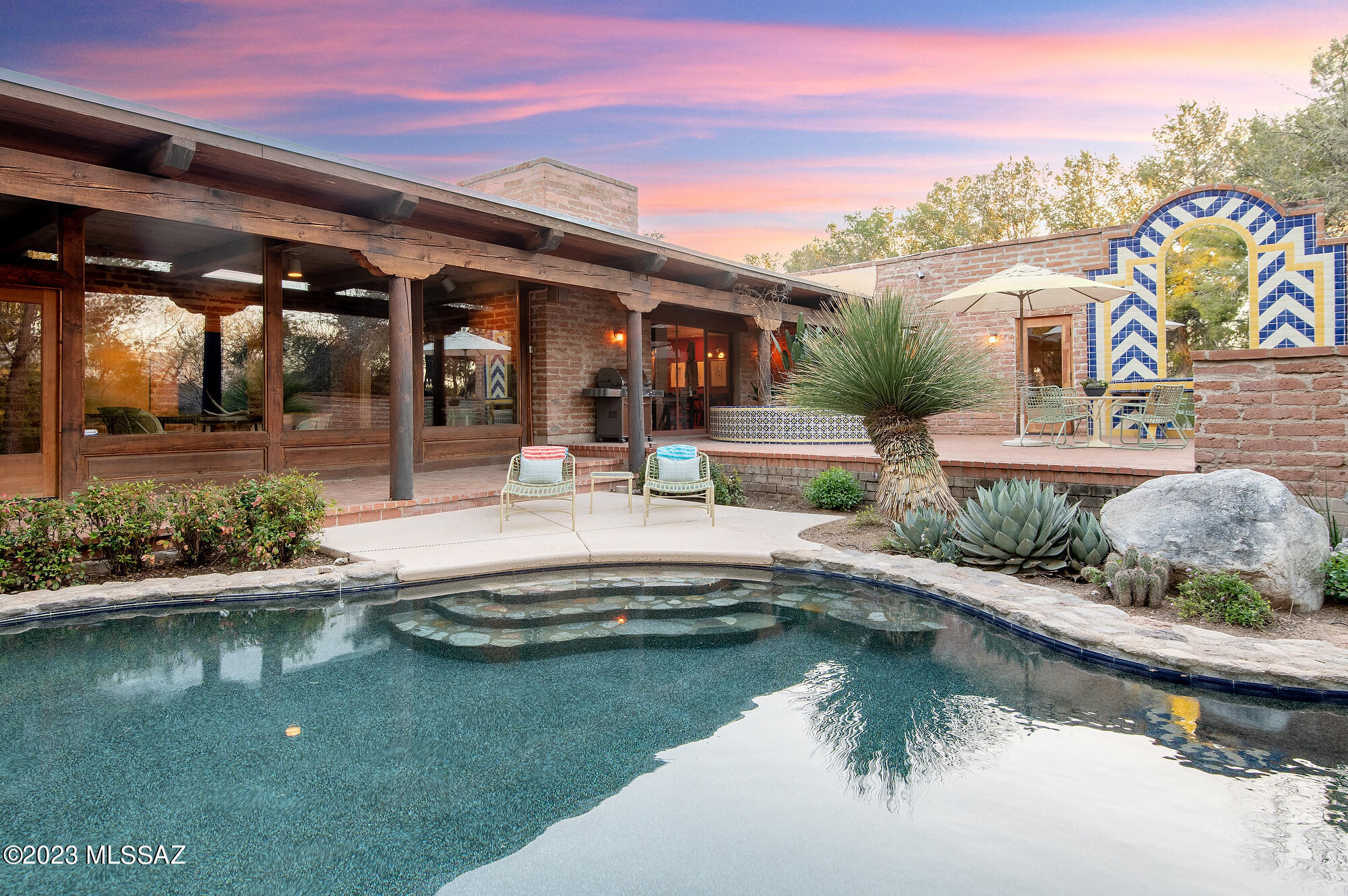 This exquisite adobe home is situated on nearly four private acres in the Old Ft. Lowell District. For five decades the current owners have stewarded this property through countless improvements, creating a unique and enchanting compound. A primary residence, spacious detached artist's studio, two car carport, and three car garage complete this sprawling estate. Historic details meld with modern styling in the three bedroom, two and a half bathroom main home. Beamed ceilings, expansive windows, and custom touches throughout imbue this home with a serene and refined aesthetic. Each space has views of mature vegetation, mountain views, or intimate spaces for entertaining or just enjoying our phenomenal Sonoran Desert climate. Minutes to TMC hospital, Sabino Canyon, and The Loop.
