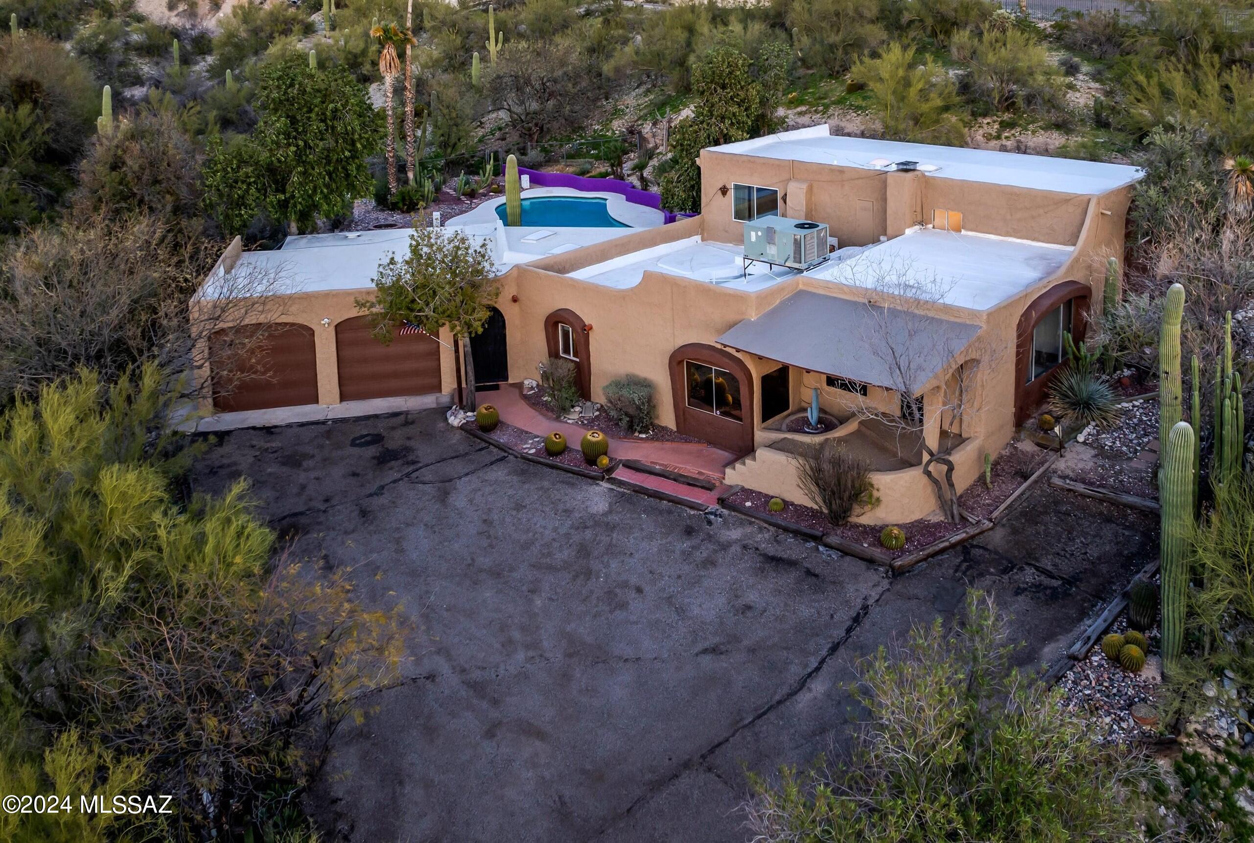 2-acre property with No HOA and No CCR's. NEW A/C installed.  NEW Roof coating. This beautiful 4-bedroom, 3-bathroom residence boasts a meticulously maintained open floor plan with original details that add character and charm. As you enter, you'll be intrigued by the polished Saltillo Tile. The living room featuring a wood burning fireplace and ample shelving, creating a cozy and inviting atmosphere. The great room is adorned with windows that frame breathtaking views of the city and natural desert. The kitchen opens to a spacious dining room that leads into a Spanish-style courtyard. The master bedroom is a sanctuary with windows providing stunning mountain views. The three additional bedrooms are bright and has NEW carpet, ensuring comfort for family or guests. The full guest bathroom features Spanish Tile surfacing handmade ceramic fixtures. Outside, the beautifully manicured desert-scape yards surround a very large pool pool and a wood burning firepit. The backyard is a retreat with multiple outdoor entertaining spaces, including a covered area with a built-in grill and tiled countertops for al fresco dining. The landscaping is maintained, and the land goes beyond the backyard wall allowing more privacy. 
Adjacent to the two-car garage, you'll find a generous shelved storage/workspace, providing flexibility for various needs.
Conveniently located near many restaurants and shopping area this home offers a perfect blend of tranquility and accessibility. Don't miss the opportunity to make this exceptional property your own. Home Inspection has been performed with ALL repairs completed.