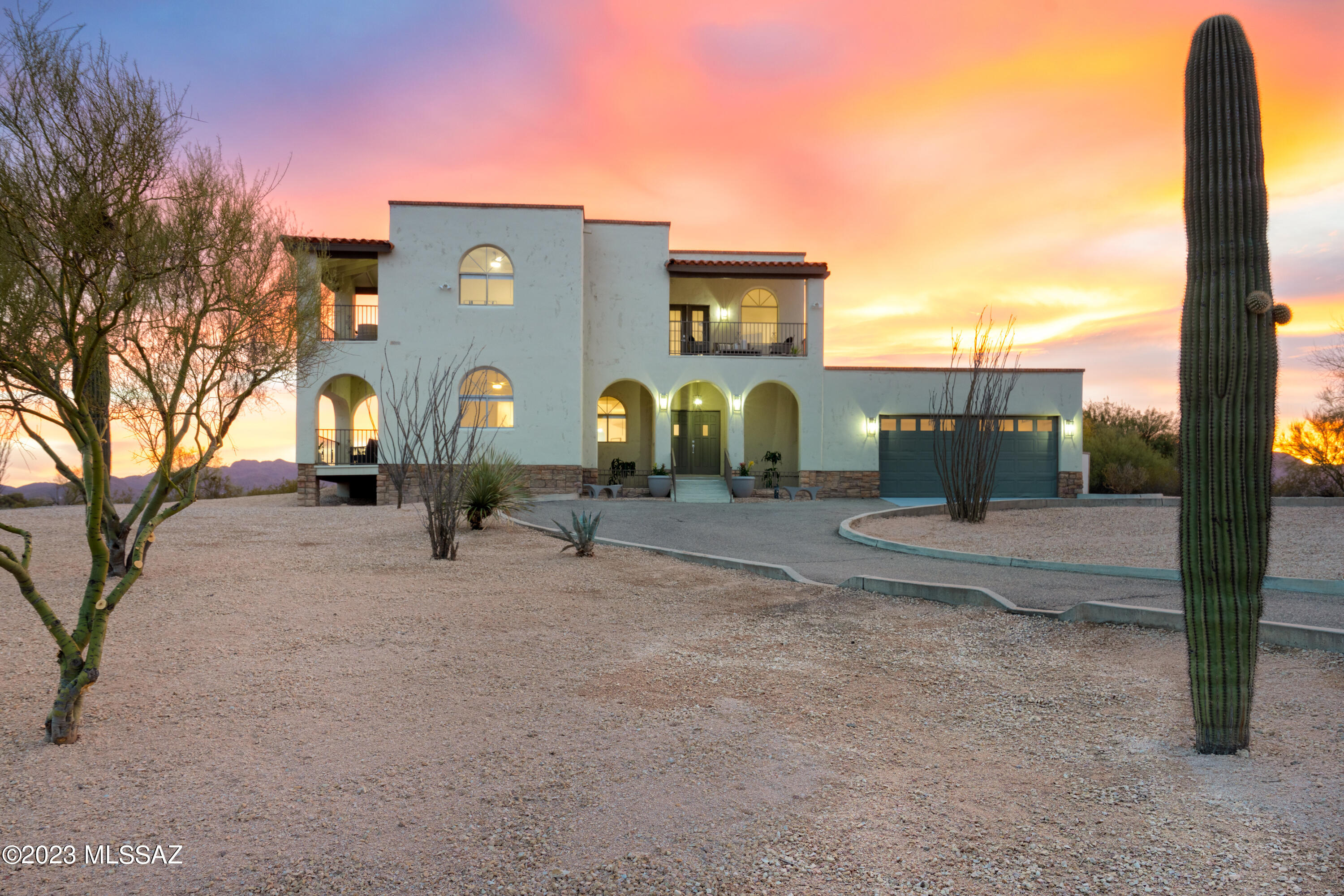 SELLER WILL COUNTER OR ACCEPT offers ranging from $925,000-950,000.  Experience breathtaking 360-degree mountain, city, sunrise and sunset views at this stately five bedroom, three bathroom two-story home! Completely remodeled, this Mediterranean-meets-Modern marvel greets you with soaring ceilings, arched windows and walls, dramatic living room fireplace with a magnificent cascading chandelier. Abundant natural lighting throughout with balconies off both the loft and primary bedroom give you an unparalleled view of the 'Old Pueblo'! Perched on this high saguaro-studded lot and well over an acre, there is room for a pool or guesthouse. Large kitchen features quartz countertops, stainless steel appliances, gas cooktop and bar island with separate breakfast nook area. (Continued...) Escape into your primary suite and luxuriate in the slipper soaking tub while gazing at the valley views!  Along with the ample interior closet and storage space, there is added storage in both the oversized garage and shed/workshop. New electrical panel and all poly removed! Enjoy picturesque sunsets from one of your multiple patio areas or relax around the fire-pit on a chilly desert night. Perfect home for entertaining or daydreaming in your new home office... - schedule your tour today!