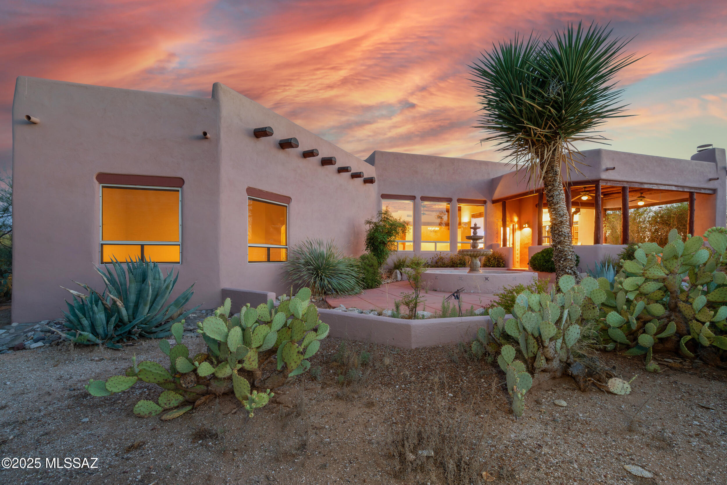 Exceptional value meets refined elegance in coveted Wild Horse Ranch. This exquisite residence captivates with soaring 15-foot ceilings and sweeping vistas from every room, delivering an unparalleled sense of space and serenity. Masterfully appointed with artisanal cabinetry featuring ocotillo accents, hand-painted sinks, and vibrant Mexican tilework, the home embodies a rich blend of craftsmanship and Southwestern sophistication. The gourmet kitchen is a culinary sanctuary, while dual-season patios - one with a charming beehive fireplace - create seamless indoor-outdoor living. The expansive primary bathroom offers a spa-like retreat, complete with his-and-hers walk-in closets, a luxurious jetted soaking tub, and a separate shower. Modern upgrades include a 30-amp RV/car charger, water softener, dual forced-air heating systems, and dual Trane air conditioners for year-round climate control. A residence that offers luxury, character, and a truly timeless desert lifestyle.