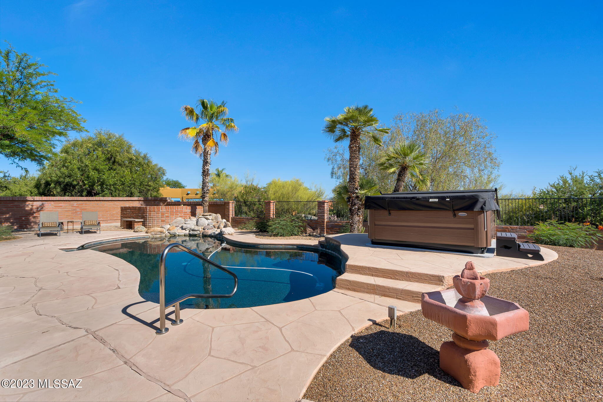 Stunning adobe brick home nestled in the prestigious Catalina Foothills!  Vacation everyday in the secluded resort style backyard featuring a sparkling pebble tec pool with rock feature, hot tub, blt in fireplace, waterless lawn, huge covered patio and amazing views! This lovingly cared for home features: gleaming granite countertops, gas cooktop, wall oven & microwave, large pantry & loads of cabinet space, & spacious dining area situated just off the kitchen. Both living room & family rooms are highlighted by a charming beehive fireplace. Family room features a wet bar perfect for entertaining, with multiple sliders leading to the bkyd. Ceiling fans throughout,  dual sinks in both bathrooms, upgraded vanities & surrounds, 2 private patios off the primary suite. Updated & open floorplan! Inviting wrought iron gated courtyard with flagstone and soothing waterfall.  Sliders from both kitchen & family for wonderful entertaining. The list goes on!