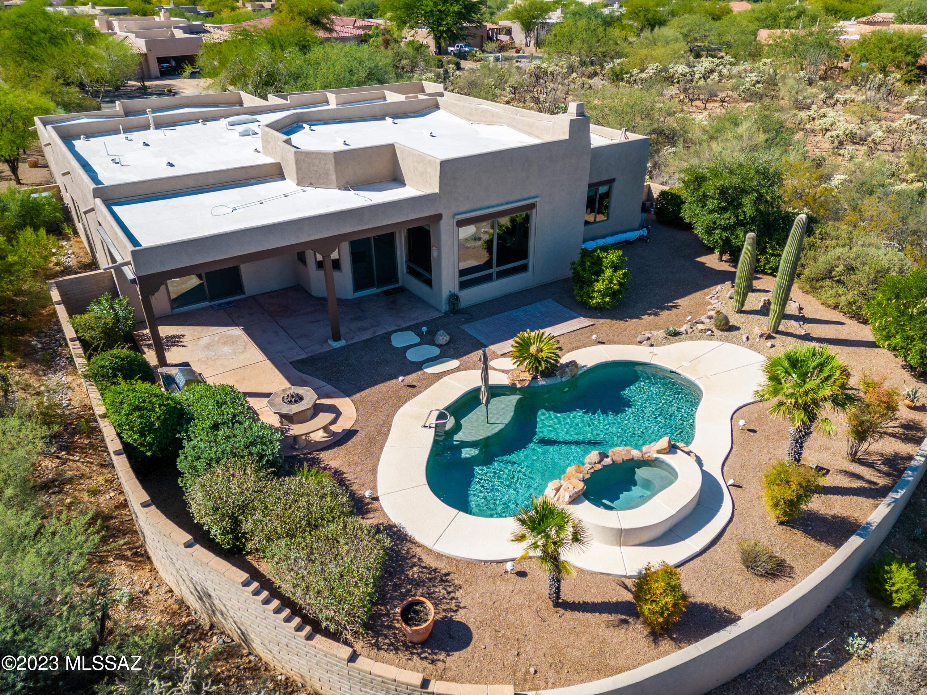 Freedom and tranquility are yours in this lovely, meticulously cared for 3 bedroom, 3 bathroom, 3 car garage home in the private and peaceful Green Valley, Arizona.  This highly upgraded 2,873 sqft property provides retreat-style living with mountain views and desert landscapes in every direction.  Relax in your refreshing pool and spa as you enjoy sunrises, sunsets, and no neighbors behind for extra solitude.  Spend additional time in your backyard with friends and family, enjoying your gas fire pit and built-in barbeque.  Inside, the views continue through large, wood-cased windows in almost every room.  Open kitchen boasts stainless appliances, gas stove top, tons of cabinets, granite countertops, and large center island.  Kitchen looks into inviting breakfast nook and spacious living room with cozy beehive fireplace.  Den and formal dining room in the front of your home provide fantastic additional living spaces, and the luxurious primary suite features a spacious sleep space with stunning views from the exterior sliding doors.  The large primary bathroom boasts two separate sinks with long vanities, beautifully tiled shower with bench, relaxing jetted tub, and spacious walk-in closet.  The oversized 3 car garage provides plenty of space and extra storage.  Washer/dryer convey in laundry room with cabinets for storage and utility sink.  Beautiful wooden doors throughout.  Welcome home to your new happy place!