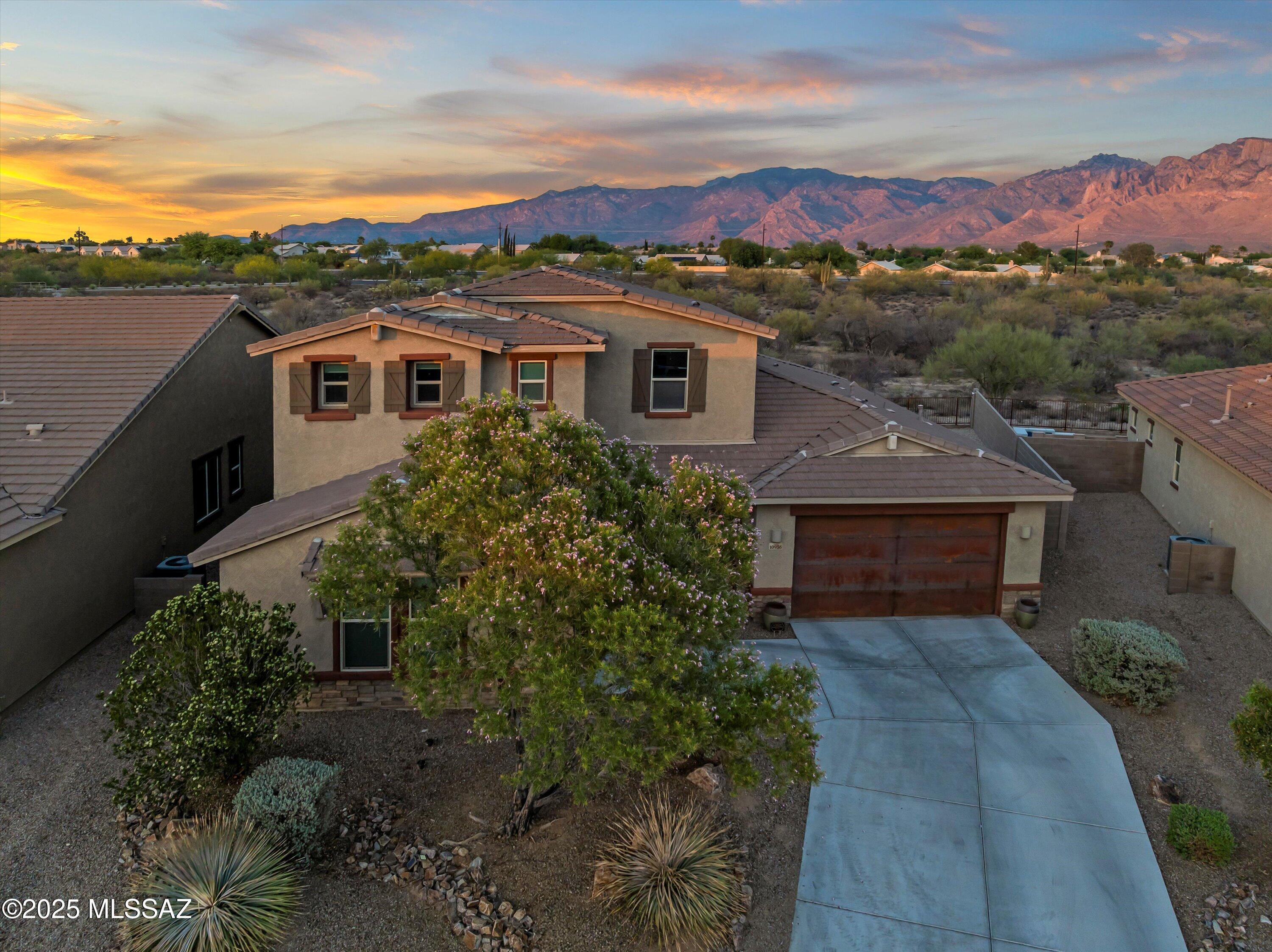 Stunning Two-Story Home with Unobstructed Catalina Mountain Views
This beautiful home boasts breathtaking, panoramic views of the Catalina Mountains and features a thoughtfully designed open-concept layout perfect for everyday living and entertaining. The modern kitchen is a chef's dream, equipped with stainless steel appliances, granite countertops, a spacious island, and a butler's pantry with a large walk-in pantry for added storage and convenience.
With 5 bedrooms and 3.5 bathrooms, there's plenty of room for the whole family. The primary suite is located on the main floor and offers a luxurious retreat with a spa-like en-suite bath, dual vanities, a huge walk-in shower, and an expansive walk-in closet.
Upstairs, a spacious loft provides additional living space and includes built-in surround sound, electric blinds, a built-in laundry chute to the downstairs laundry room, and a pocket office that's plumbed for an optional wet bar. Two of the upstairs bedrooms share a Jack & Jill bathroom, while the other two share a bathroom with dual sinks.
This home is filled with premium upgrades, including surround sound in the loft, family room, patio, formal dining room, and owner's suite. Enjoy the convenience of electric blinds in the loft, family room, and breakfast nook.
The 3-car garage features a unique layout, with two bays on one side of the driveway and a single bay on the opposite sideboth offering generous overhead storage.
Perfectly situated near top-rated schools, Oro Valley dining, hospitals, golf courses, pickleball courts, and sports complexes, this home combines luxury, comfort, and location in one exceptional package.