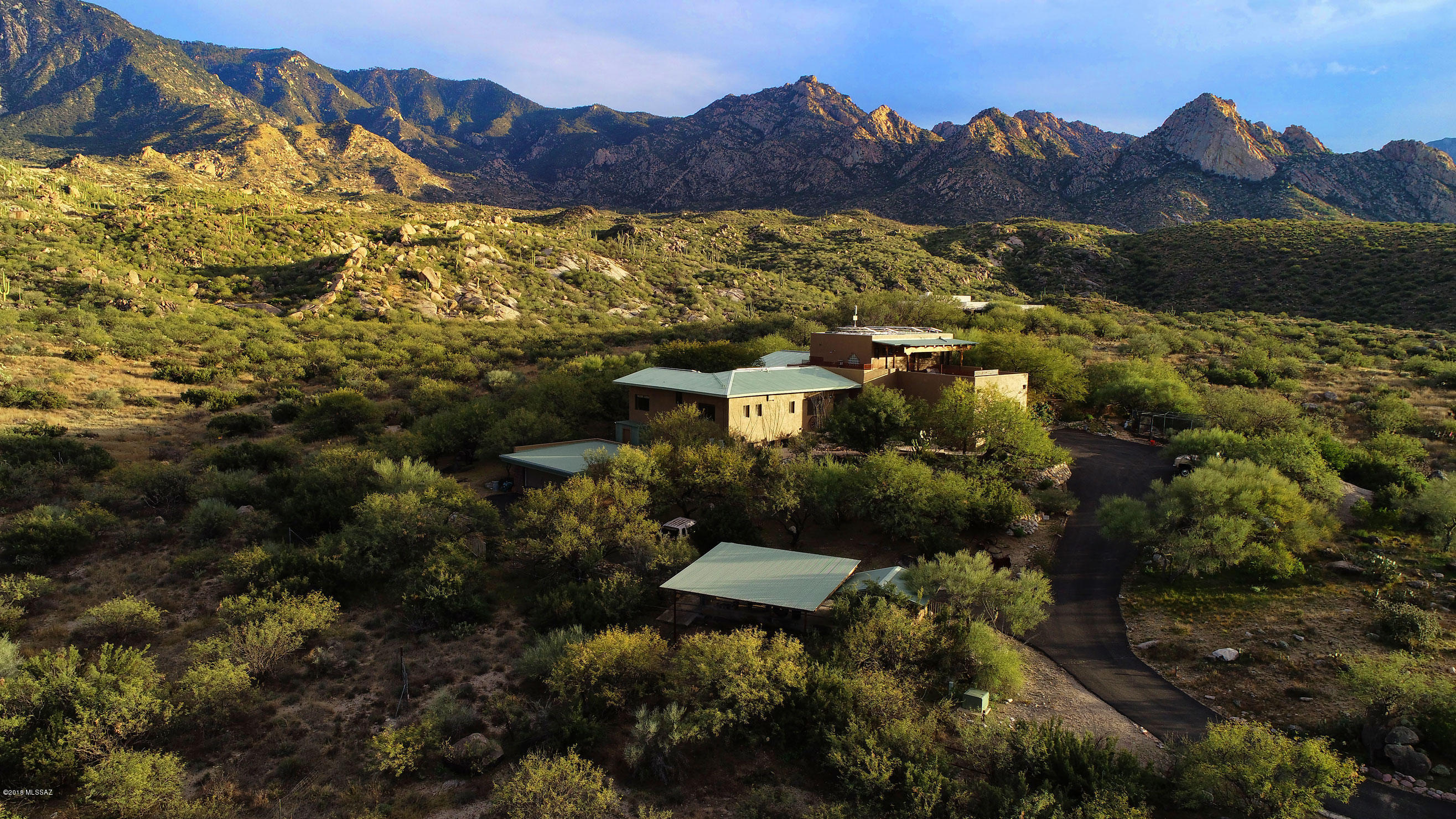 Breathtaking Huge Unobstructed views of the Catalina Mountains, sunsets are great as well. 5249 sqft, 5 bedrooms, 4 baths, 4.5 garage spaces, 2 carports. Top floor Master bedroom features wood floors, views to the Catalinas, walk in shower, garden jet tub, dual vanities, large walk-in closet, viewing decks and outdoor shower. Downstairs to the Large Great Room with fireplace, the East wall is all window and brings the mountains and gardens into the home, Flagstone flooring. Large hallway/sitting area off of Great Room designed especially to sit, relax and enjoy the views.
Kitchen opens to Great Room, granite and copper counter tops, great outdoor views while preparing meals, breakfast bar and tea alcove. PLEASE SEE VIDEO AND VIRTUAL TOUR/3-D SHOWCASE. Bedrooms 2 & 3 have Jack & JIll bathroom, walk-in closets, bedroom 4 currently used as office. Bedroom 5 is bottom level with own entrance, large living area,bathroom and full kitchen.
Two garages, first is a 2 car and accesses the kitchen entry, the second garage is detached and is 2 car and room for a golf cart, currently used as a workshop. Please see attached floor plan and virtual tour.