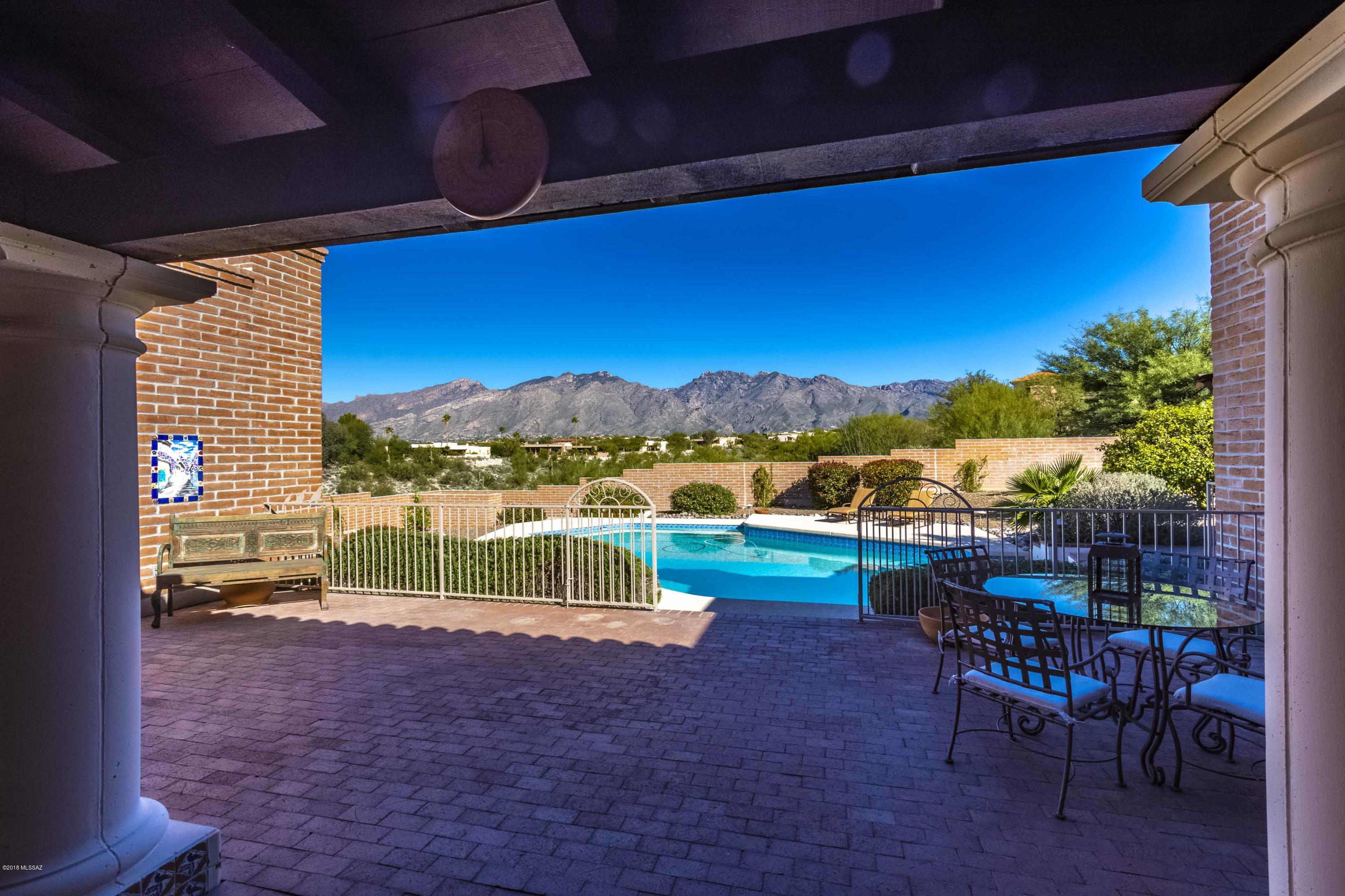 Spectacular mountain and sparkling city light views are enjoyed from this beautiful burnt adobe home on 1.63 acres in the Catalina Foothills. Superb layout with large entertaining spaces and bedrooms all which look out to the breathtaking views. Fourth bedroom would make a great guest suite, workshop, artist studio or pilates room with 2 rooms off of it that can be used for either office, exercise room or storage or a combination of. Tons of flexibility and options.  Enjoy the sparkling pool/spa, relax on the covered brick patio or detox in the gorgeous sauna in master suite. Soothing colors, Saltillo tile flooring, Mexican Talavera tile, tons of storage throughout.  Open kitchen with center island, pantry, wetbar, buffet, stainless appliances and plenty of room for your kitchen tabl