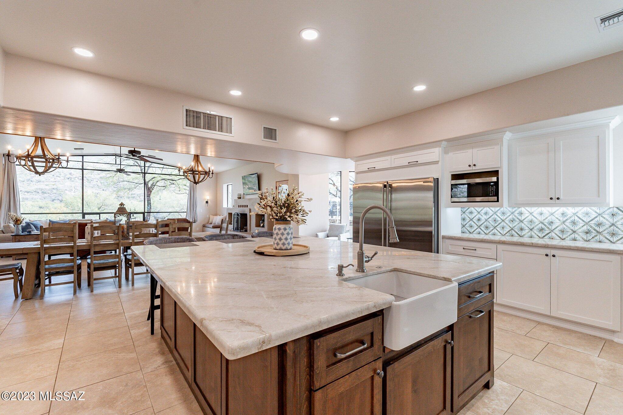 An impressive 4.56 acre estate bordering thousands of acres of National Forest w/ tremendous views of the Catalina Mountains right outside your back door! Luxuriously remodeled, this 5 bedroom 4 bath open floorplan has 5184 sq ft. w/ a private guest suite. Main level has new porcelain tile & massive 30'x28' great room w/ a wall of windows looking right at the mountains. Reimagined kitchen w/custom cabs,Taj Mahal quartzite counters w/ 7'x9' island, Hallman range & butler's pantry leading to spacious laundry room. Master suite w/ new vinyl plank floors & new bathroom w/ Quartzite counters & walk-in glass shower. 2 car attached garage & separate 3 car garage workshop. Grand custom metal front door & handmade French doors. Private & serene but only 10 minutes from shopping and amenities!