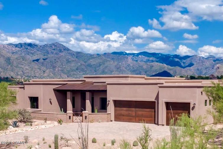 SPECTACULAR SWEEPING VIEWS OF THE CATALINA MOUNTAINS, RINCON MOUNTAINS AND SPARKLING CITY LIGHTS from every window of this NEW custom home on the ridge. RARE FIND in the FOOTHILLS. Open flowing plan, split bedrooms, gourmets dream kitchen. formal dining or den option.  Superior finishes include disappearing GLASS WALL from greatroom to patio, CUSTOM cabinets and hardware, dual islands in kitchen, OVERSIZED porcelain tiled floors and shower surrounds, granite  & natural stone tops, LINEAR GLASS GLOW FIREPLACE, stainless appliances (GE Monogram/Electrolux/GE Cafe), EXPANSIVE covered porch great for entertaining and a LUXURIOUS master suite.  RUSTIC CONTEMPORARY feel includes enclosed front courtyard, Alder 8' stained interior doors, rusted metal finish on garage/patio and concrete pavers.