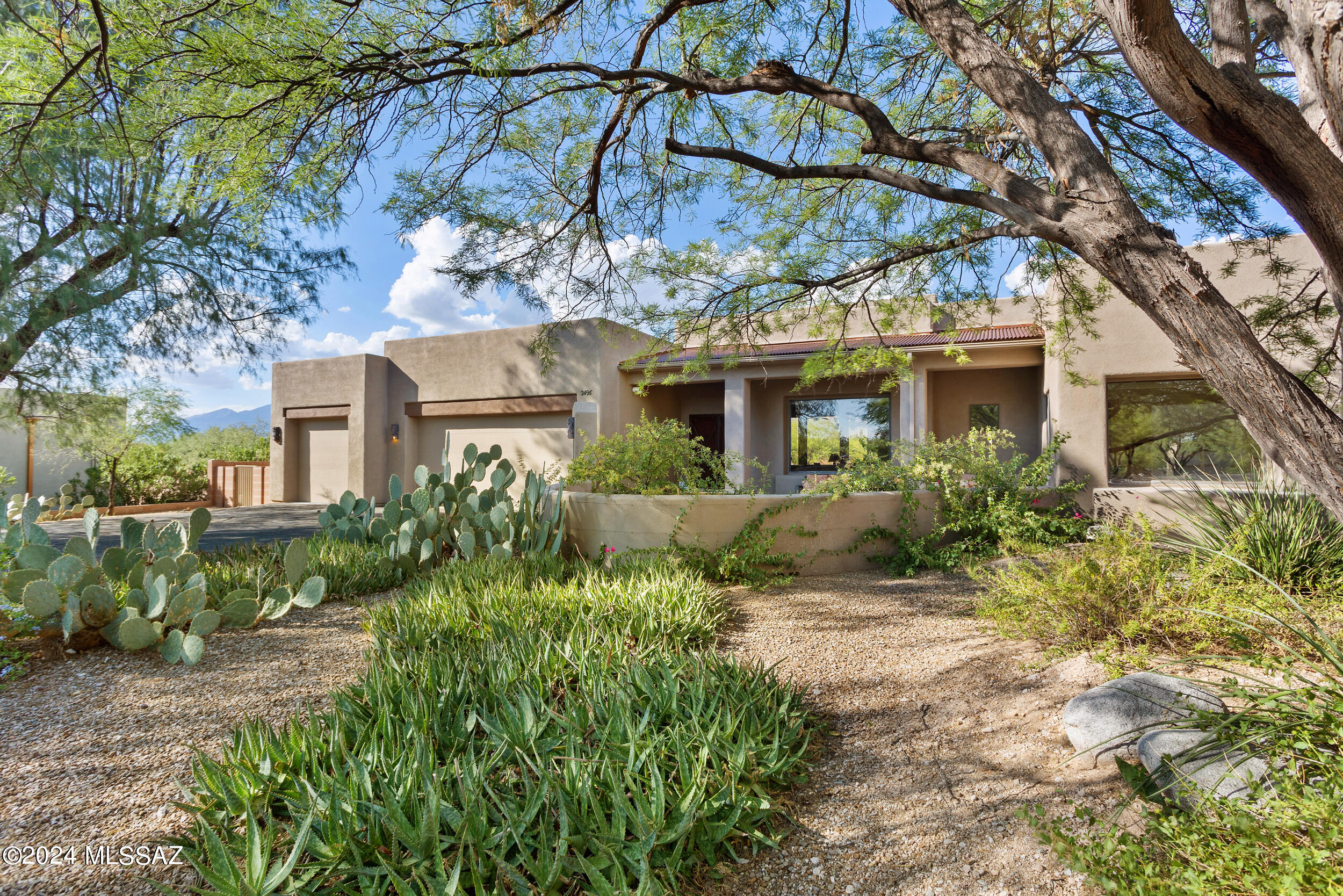 Range price $1,000,000-1,100,000 seller will accept/counter offers within this price. Located at the end of a cul de sac in The Outpost's gated community in Tanque Verde Valley, this exceptional property features  4 bedrooms & 4 full baths plus a powder room on .83 acres, breathtaking Catalina mountain views, a large yard with a pool and spa & BBQ plus a toasty firepit. This beautiful home has an open gourmet kitchen with granite countertops. Enjoy views from both a large living room and separate family room with a cozy gas fireplace. The owners suite is very spacious with a shower and tub ad double walk-in closets. Enter the courtyard with fountain. There's an oversized cooled 3 car garage with separate storage, solar system, dual air conditioners,  water softener and security prewire