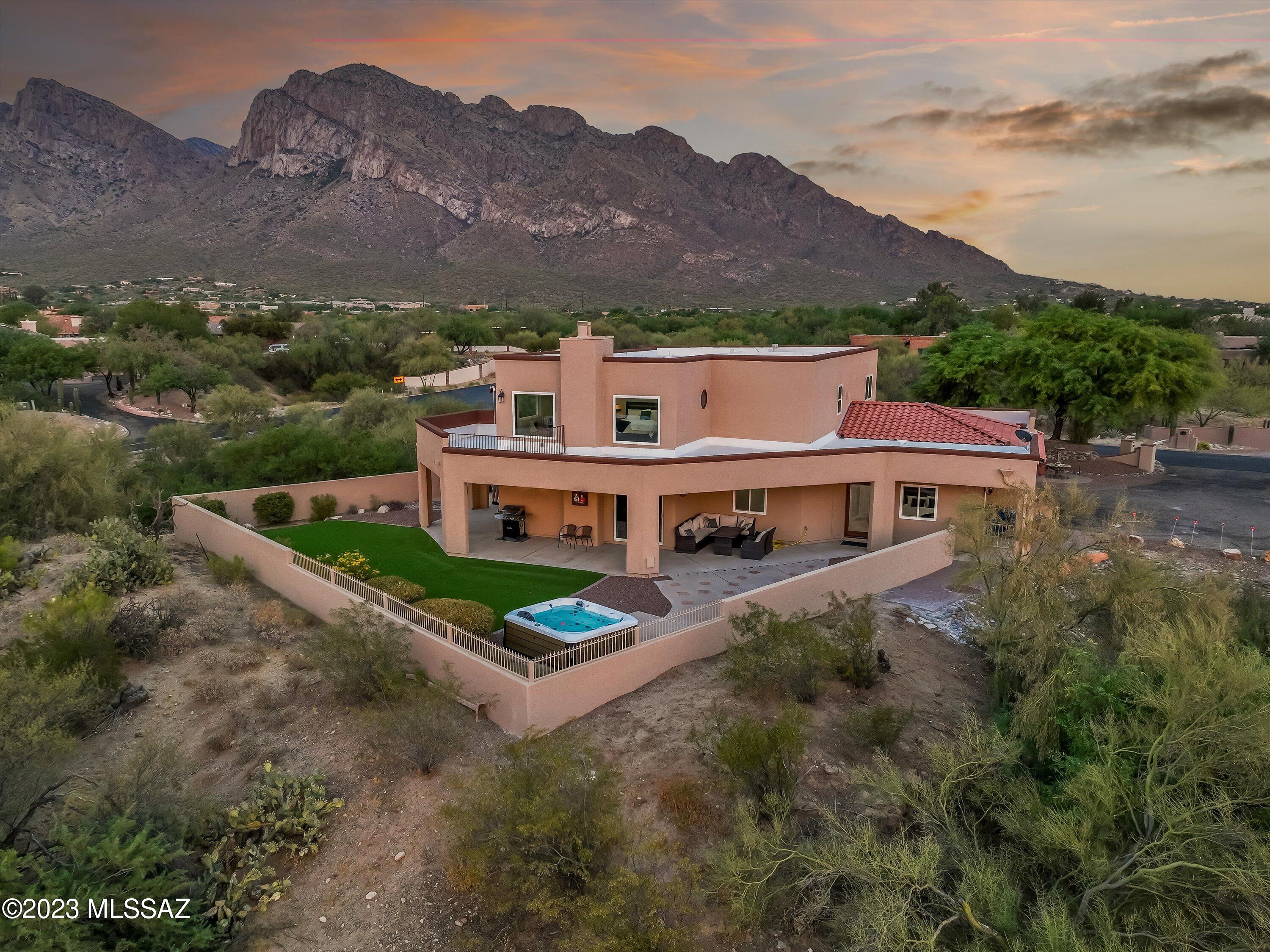 Spacious 3,914 SQFT recently remodeled hilltop estate with spectacular 360 degree views overlooking Oro Valley Country Club.  This private 5BR/4BA luxurious Northwest home sitting on a 1+ acre lot is being sold fully furnished and features a low care backyard with synthetic grass, romantic fireplace, sparkling hot tub, expansive covered patio and breathtaking mountain views, open floor plan providing an abundance of natural light, first floor guest suite / second primary bedroom with it's own entrance, roomy game room with pool table & table tennis, renovated kitchen with stainless steel appliances & granite counters, second floor primary bedroom with fireplace, walk-in closet, custom bathroom and patio and a convenient location near shopping, restaurants and world-class golf courses.