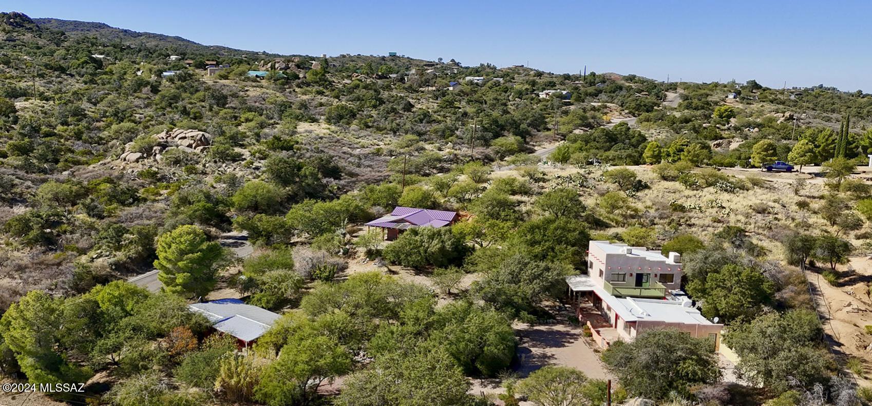 Entering into this over an acre property, past the pine and fruit trees, up the paver driveway and garden beds, you are greeted by ample outdoor space and 3 homes allowing for potential for multigenerational family living, or a tranquil rental retreat. The main home is a charming rustic Santa Fe style and features a front courtyard, multiple living areas, many wood accents, stone floors, and a wood burning fireplace. There is one bedroom downstairs and a spacious suite upstairs with a large deck and Mountain views. There are 2 guest homes on the property. (All 3 are situated allowing for privacy from the other homes.) One, recently completed, made with rammed earth. Both guest homes feature wrap around patios, metal roofs and many special accents. This property is truly one of a kind.