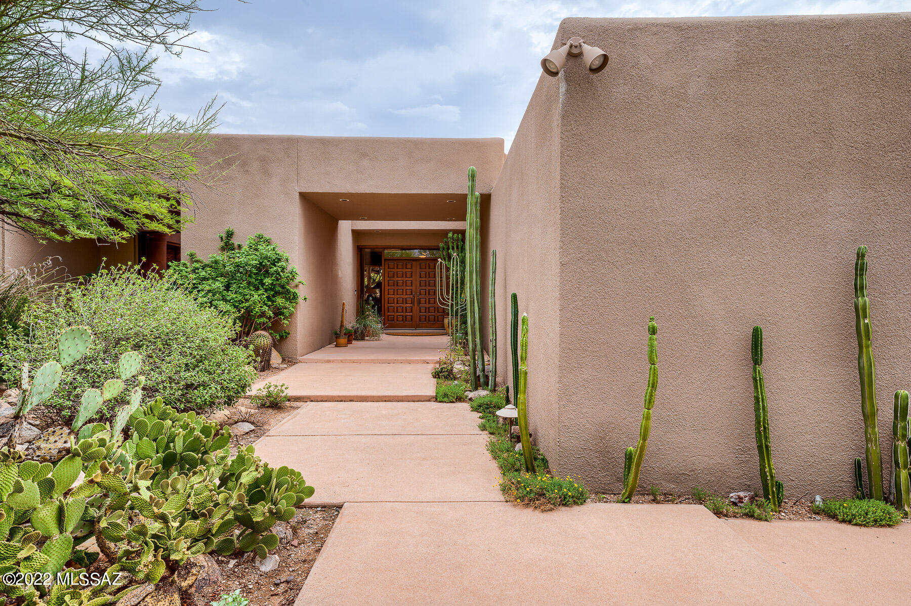 This property was designed with great care to achieve superb city and mountain views. A wrap-around covered patio immerses you in a lush desert landscape. Multiple oversized sliders in the living & dining room bring the outdoors in, perfect for viewing the storms roll by. The desirable split bedroom plan features a generously sized primary suite with gas fireplace, wood ceiling & access to the back patio. 3 additional guest rooms flank a perfect family hangout spot separate from the living room. Guests enjoy privacy in a detached guest casita, just steps out the back door. A large built-in spa is perfectly located to enjoy the view. Ideal location: walking distance to La Encantada and Manzanita Elementary, minutes from multiple hiking trails and only 7 miles to the UA Campus. The property has been lovingly maintained by one owner for over 35 years, with a newly recoated roof and recent replacements of kitchen appliances, spa pump, drip irrigation & main water line to the street.